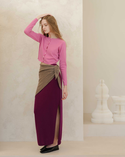 Italian cashmere skirt with side slit in plum, layered with taupe wrap detail. Ethically made knitwear paired with pink cardigan.