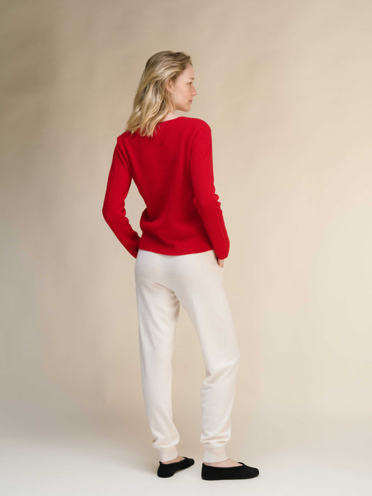 Italian knitwear Cashmere Yoga Pants 3D-Knit in ivory, paired with red sweater, showcasing soft texture and relaxed fit.
