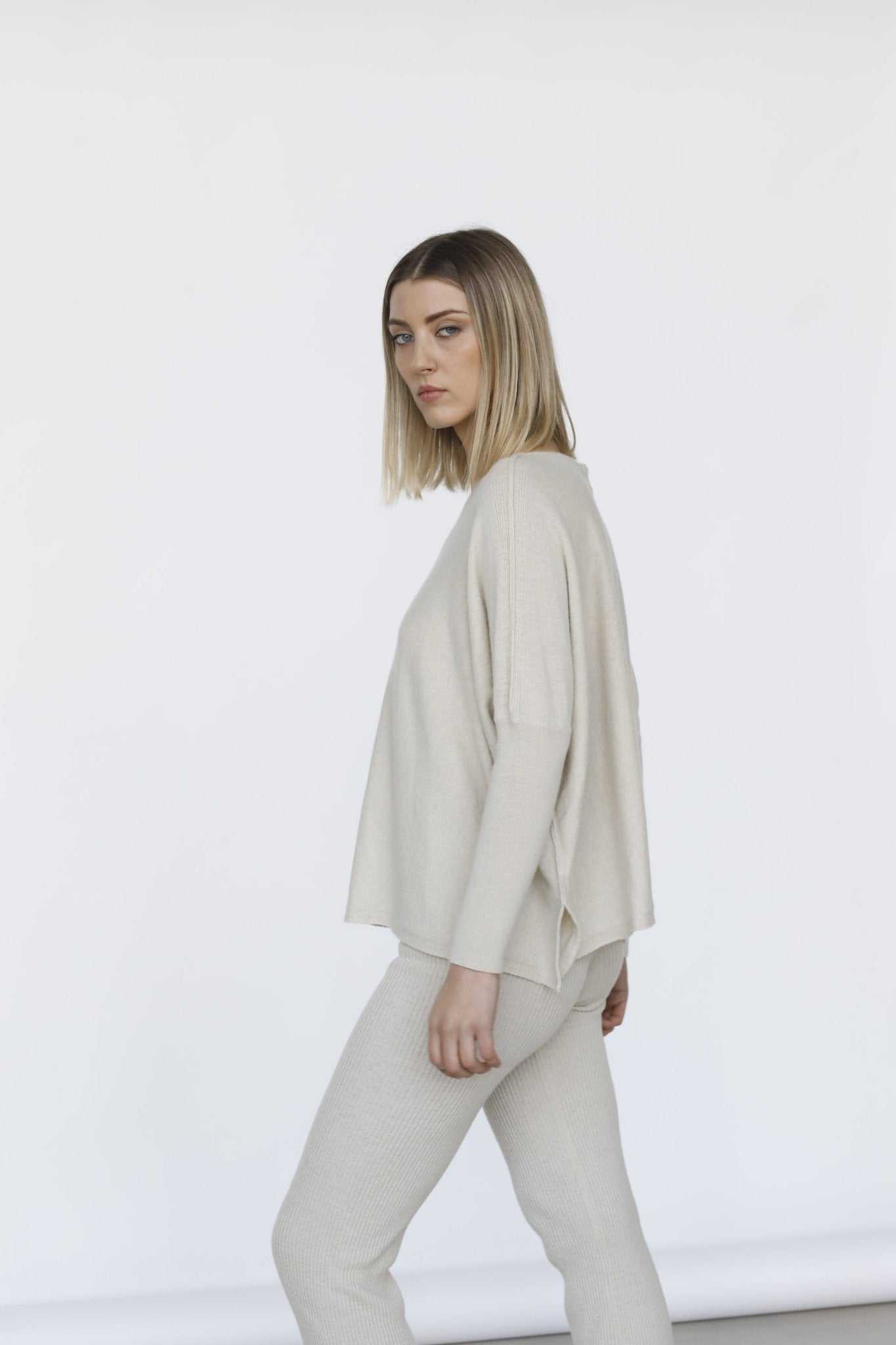 Side profile of Margot Box-Fit Wool Sweater by Tenné with visible side slits and relaxed silhouette, ideal for eco-conscious spring fashion.