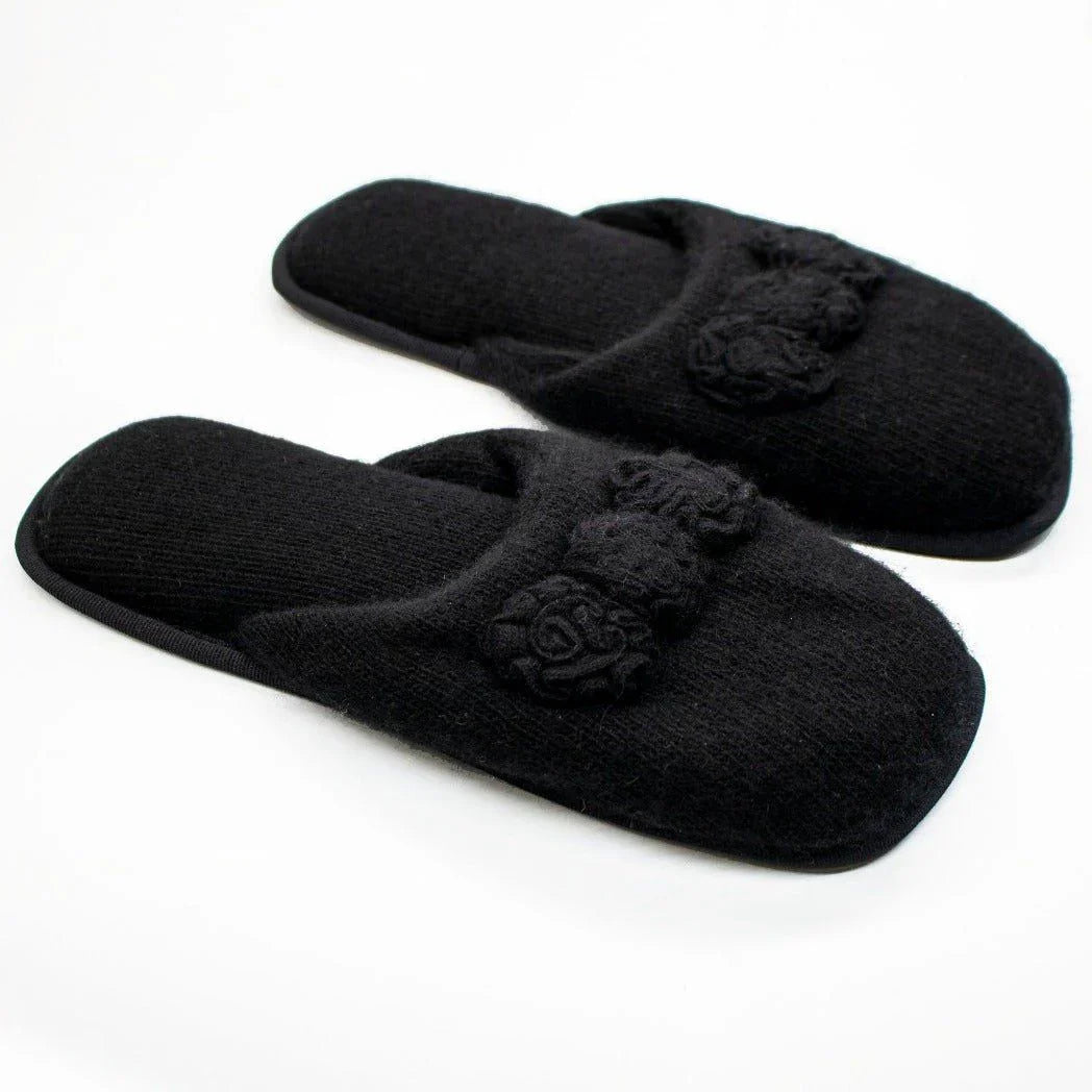 Black cashmere slippers with decorative floral details on white background
