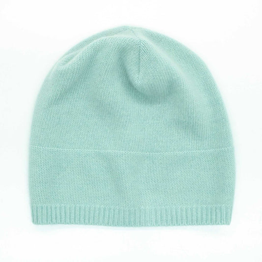 Mint green Portolano Women's Cashmere Slouchy Hat laid flat. Features soft jersey knit and reverse stitch crown detail for cozy style.