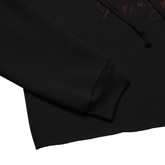 Close-up of black cropped hoodie sleeve and hem showing soft airlume cotton blend and raw edge finish for a trendy look.
