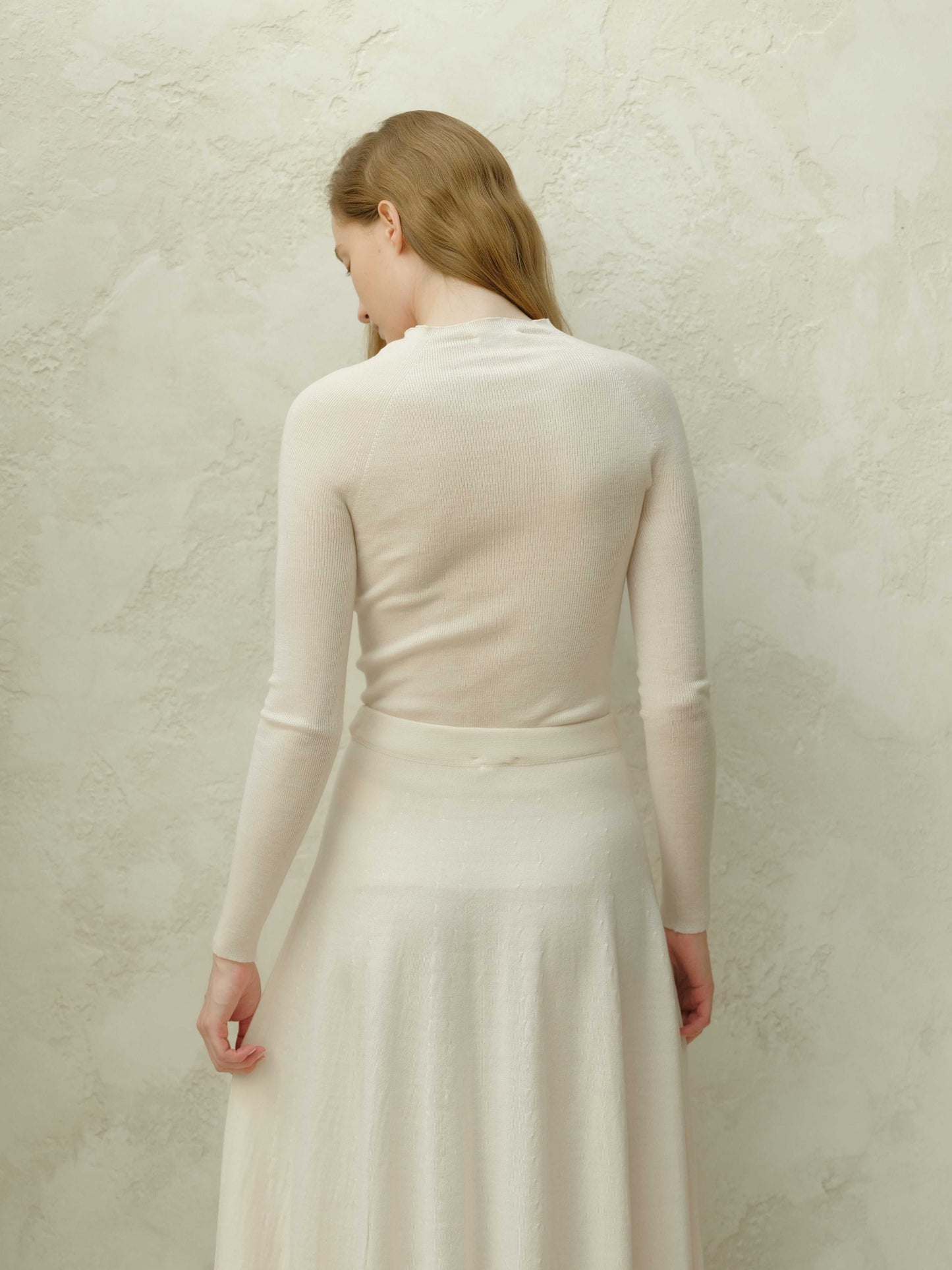 Back view of ivory slim fit ribbed crewneck in extra fine merino wool. Seamless knitwear with a smooth, elegant silhouette.