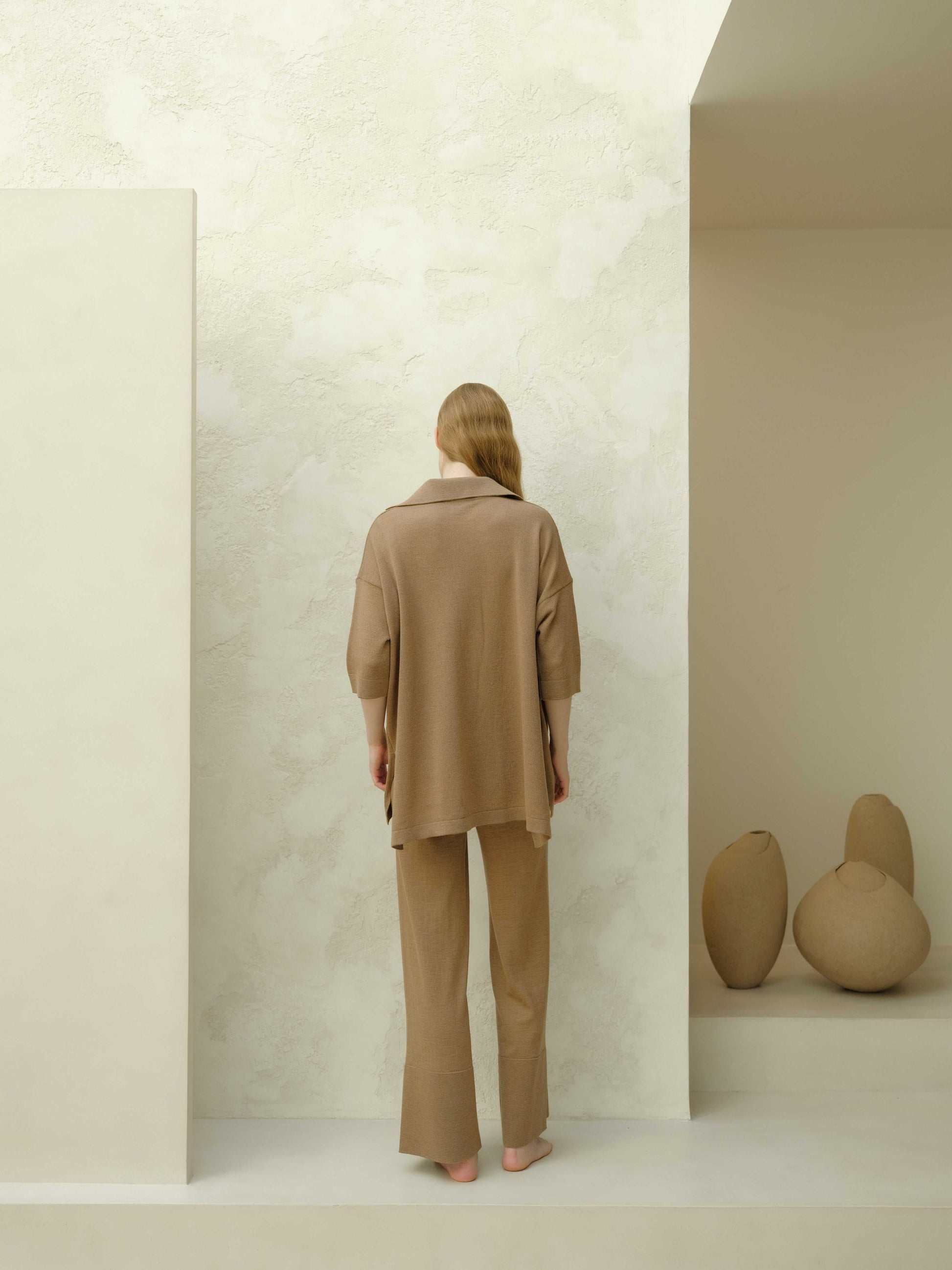 Back view of the Extra Fine Merino Wool Maxi Polo in brown, showcasing its flowy cut and sustainable knitwear design.