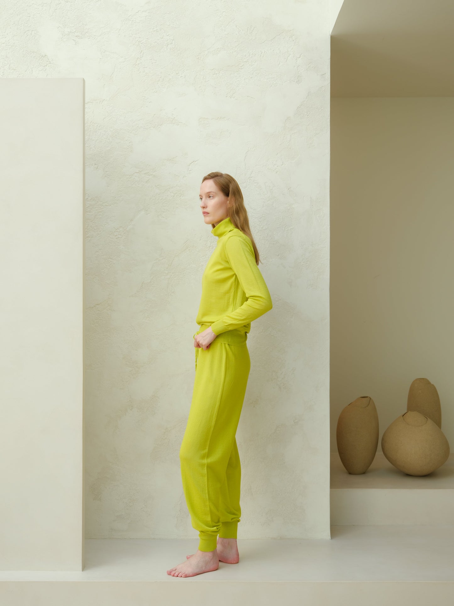 Side view of lime green Extra Fine Merino Yoga Pants by Lèmme. Sustainable Italian knit joggers for yoga and activewear.