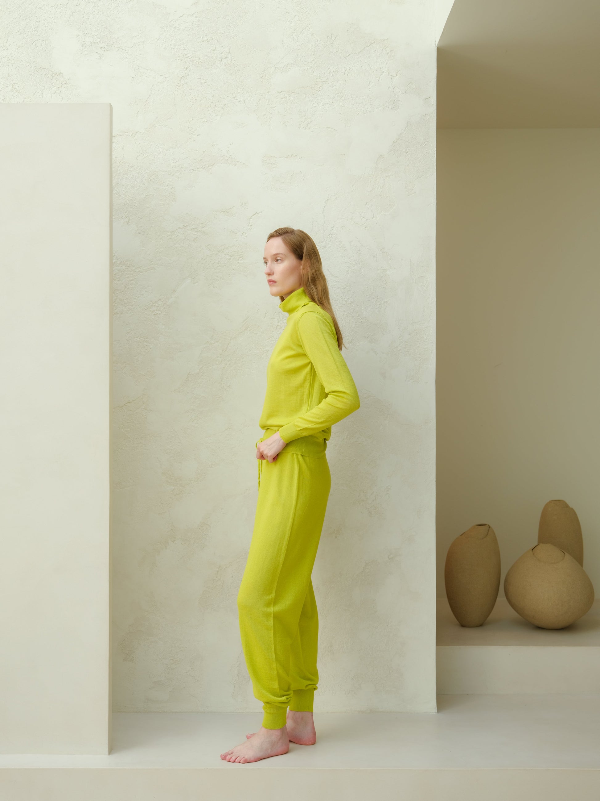 Side view of lime green Extra Fine Merino Yoga Pants by Lèmme. Sustainable Italian knit joggers for yoga and activewear.