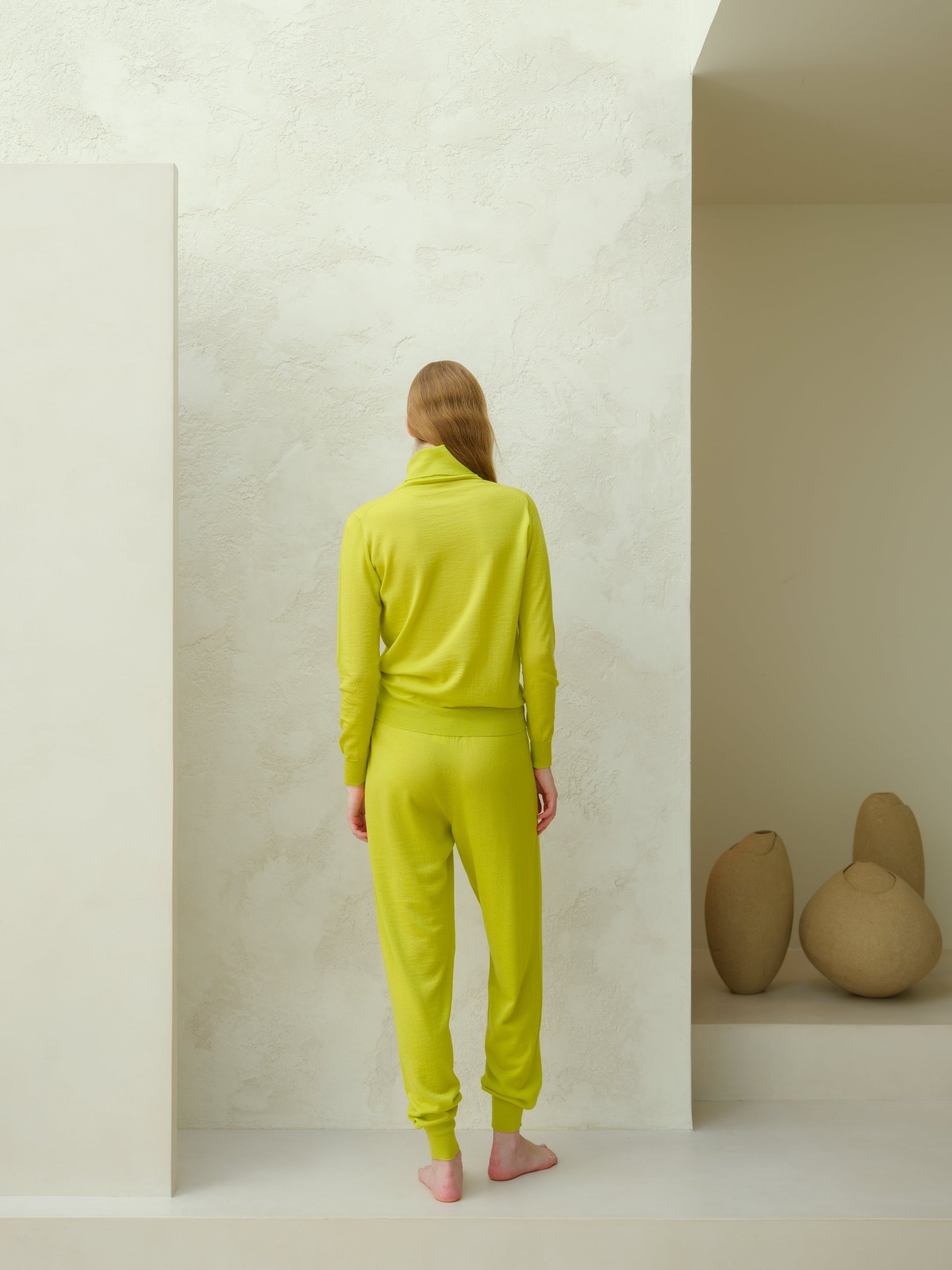 Back view of lime green Extra Fine Merino Yoga Pants by Lèmme. Premium merino wool joggers for women’s activewear.