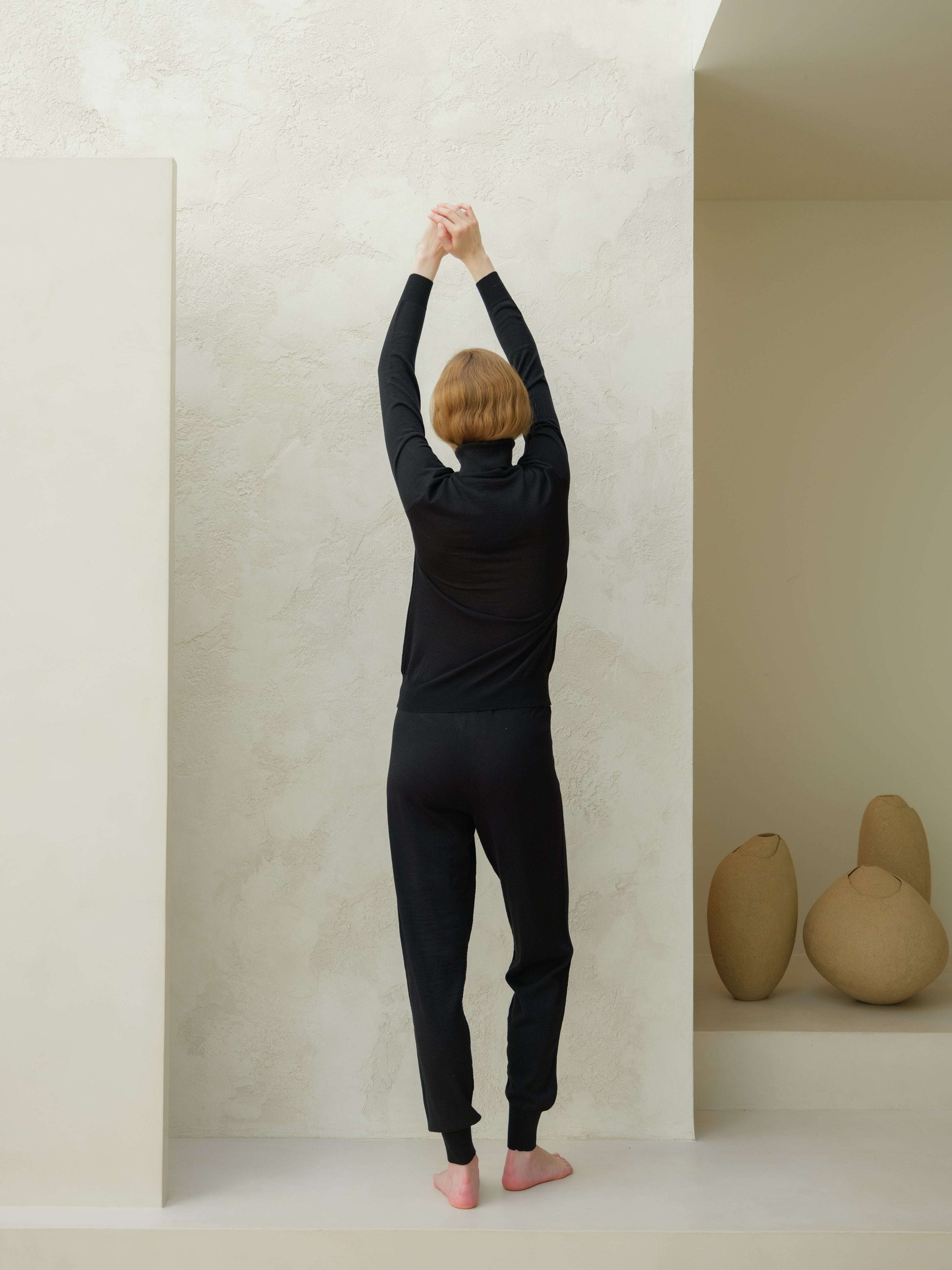 Back view of black Extra Fine Merino Yoga Pants by Lèmme. Sustainable Italian knit joggers for premium yoga wear.
