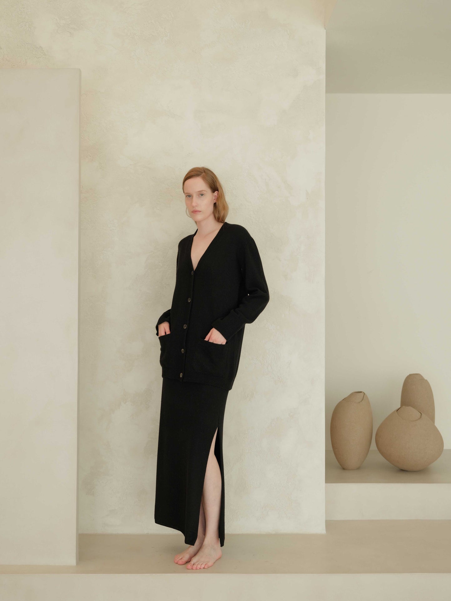 Black cashmere skirt with side slit and matching cardigan. Seamless Italian knitwear designed for timeless elegance and comfort.