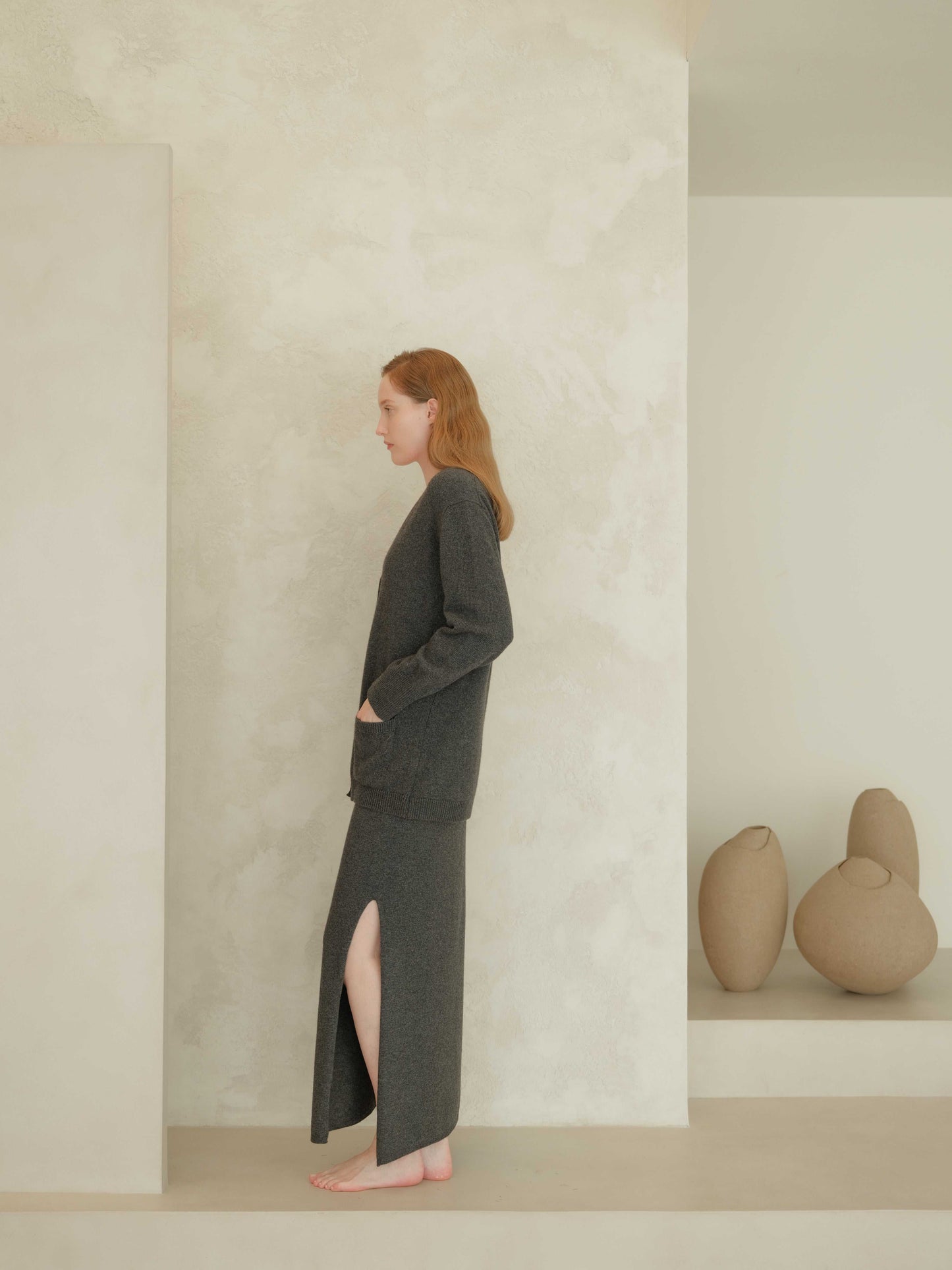 Charcoal grey cashmere skirt with side slit and matching cardigan. Ethically sourced Italian knitwear for cozy, elegant looks.