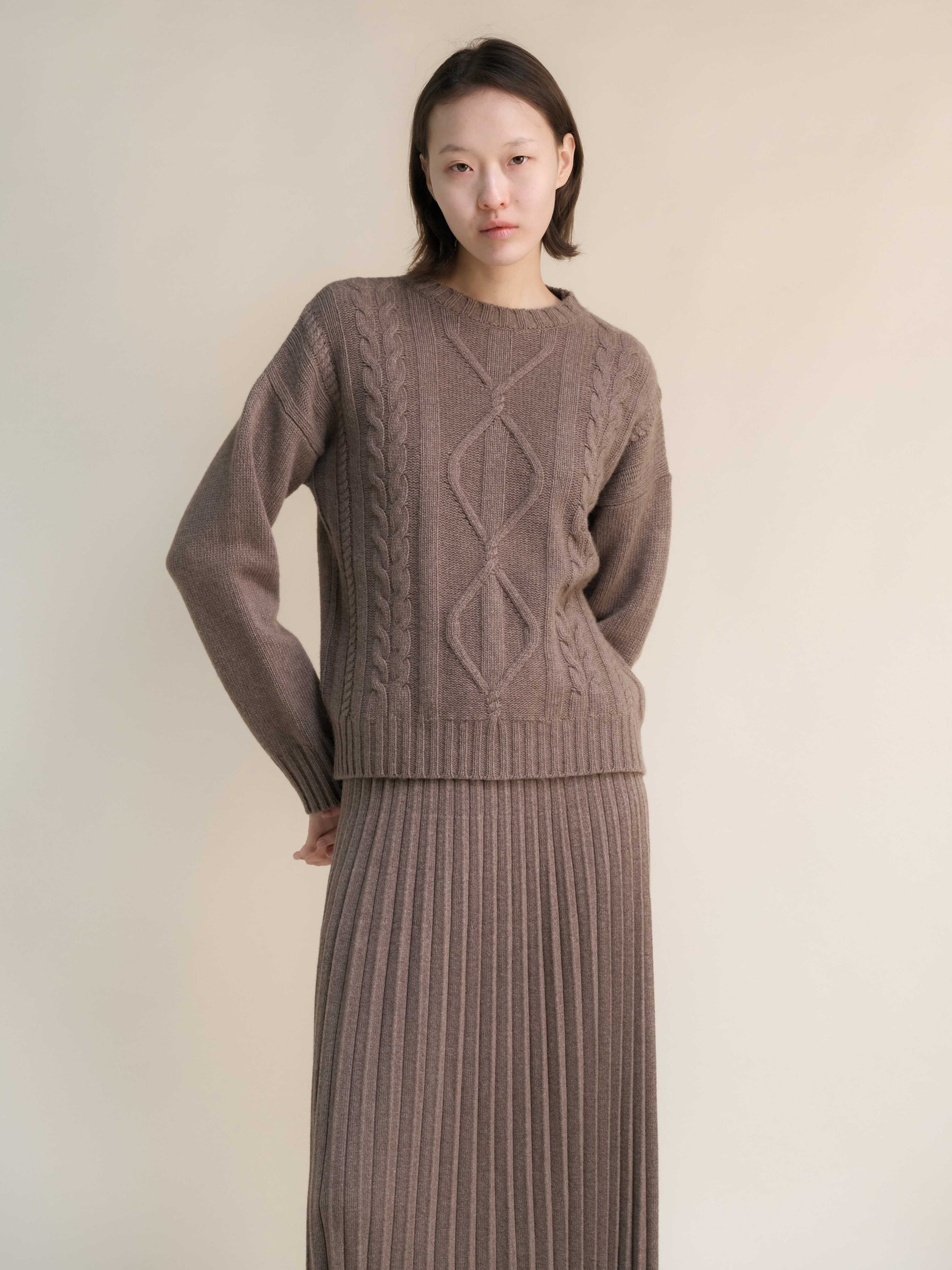 Close-up of taupe Cashmere Mix Cable Knit Sweater with ribbed skirt. HenryPawHaven sustainable apparel for elegant, cozy styling.