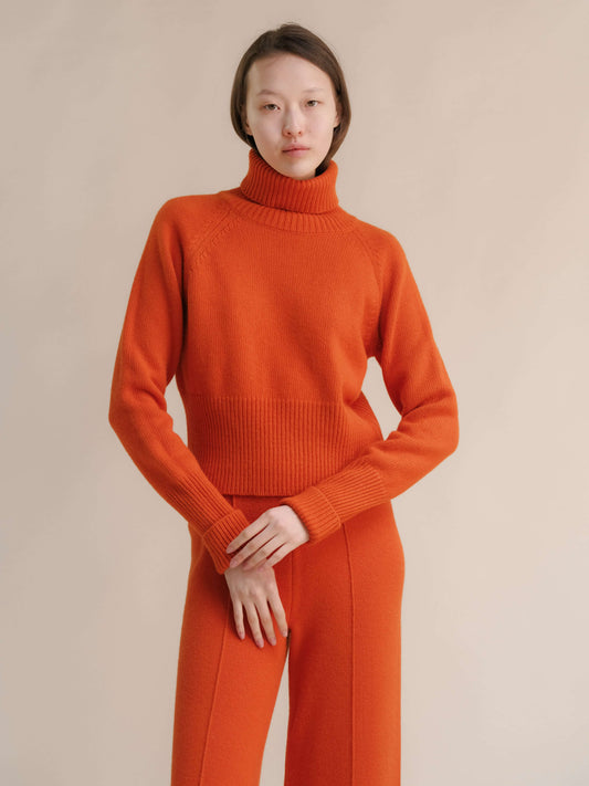 Bright orange roll-up cuff turtleneck sweater in wool-cashmere blend, cropped fit by HenryPawHaven. Italian knitwear for stylish layering.