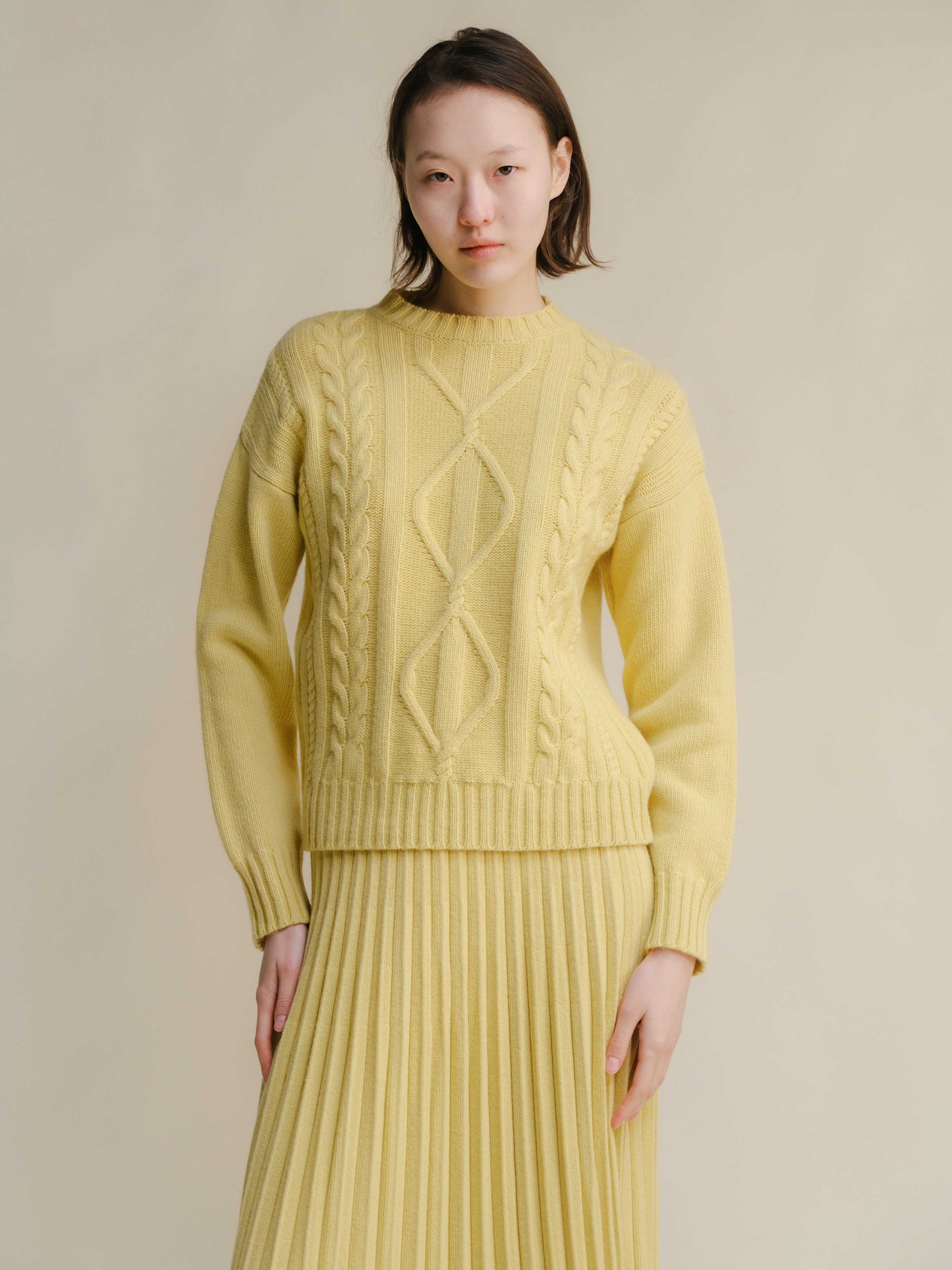 Yellow Cashmere Mix Cable Knit Sweater styled with pleated skirt. Sustainable fashion from HenryPawHaven for bright, elegant comfort.