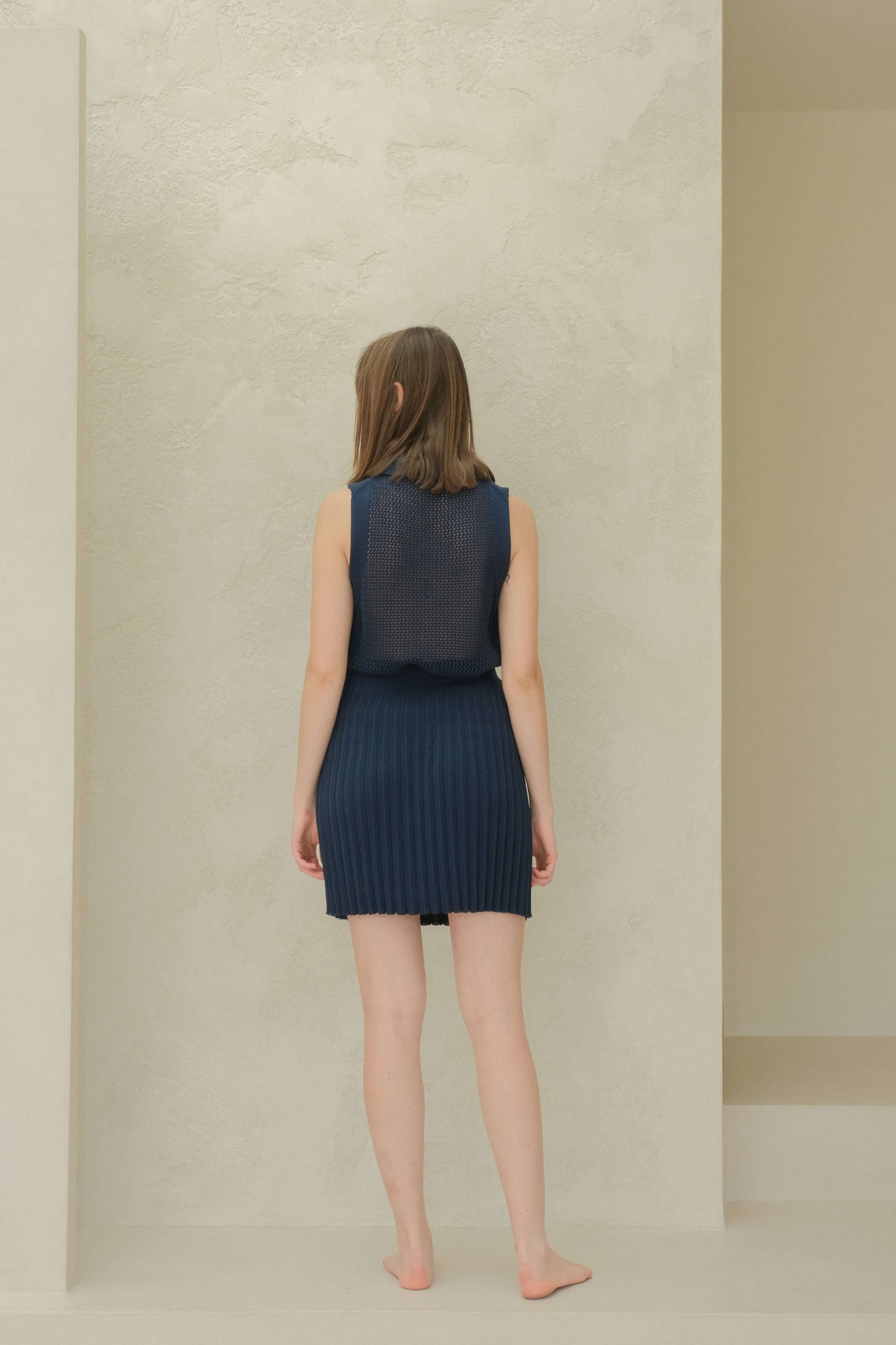 Back view of navy plissé mini skirt outfit