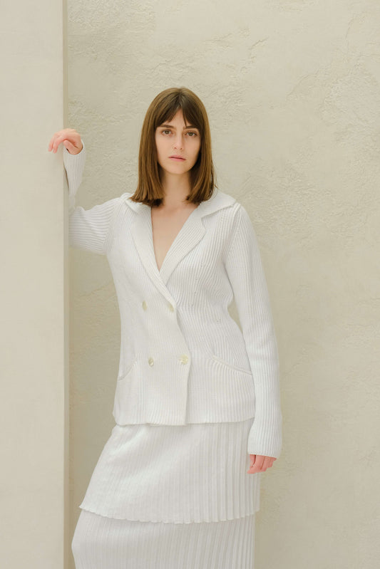 Double breasted knit jacket in white fine cotton with mother of pearl buttons, styled with matching ribbed skirt. Italian craftsmanship by Lèmme.