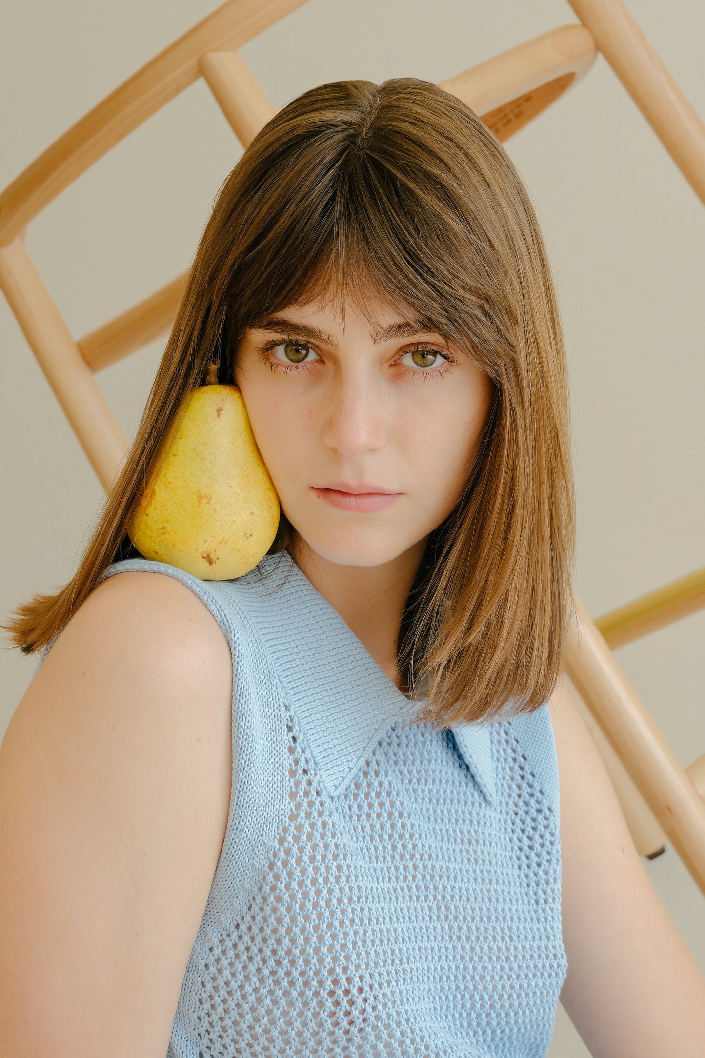 Fine Crochet Polo Tank Top in sky blue by Lèmme, styled with a pear on the shoulder. Italian knitwear in 100% extrafine merino wool.