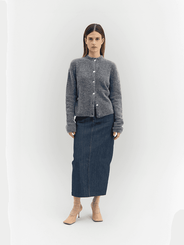Full-body view of model wearing grey Women's Fortuna Cardigan with Buttons, paired with a denim skirt, highlighting sustainable Italian knitwear.