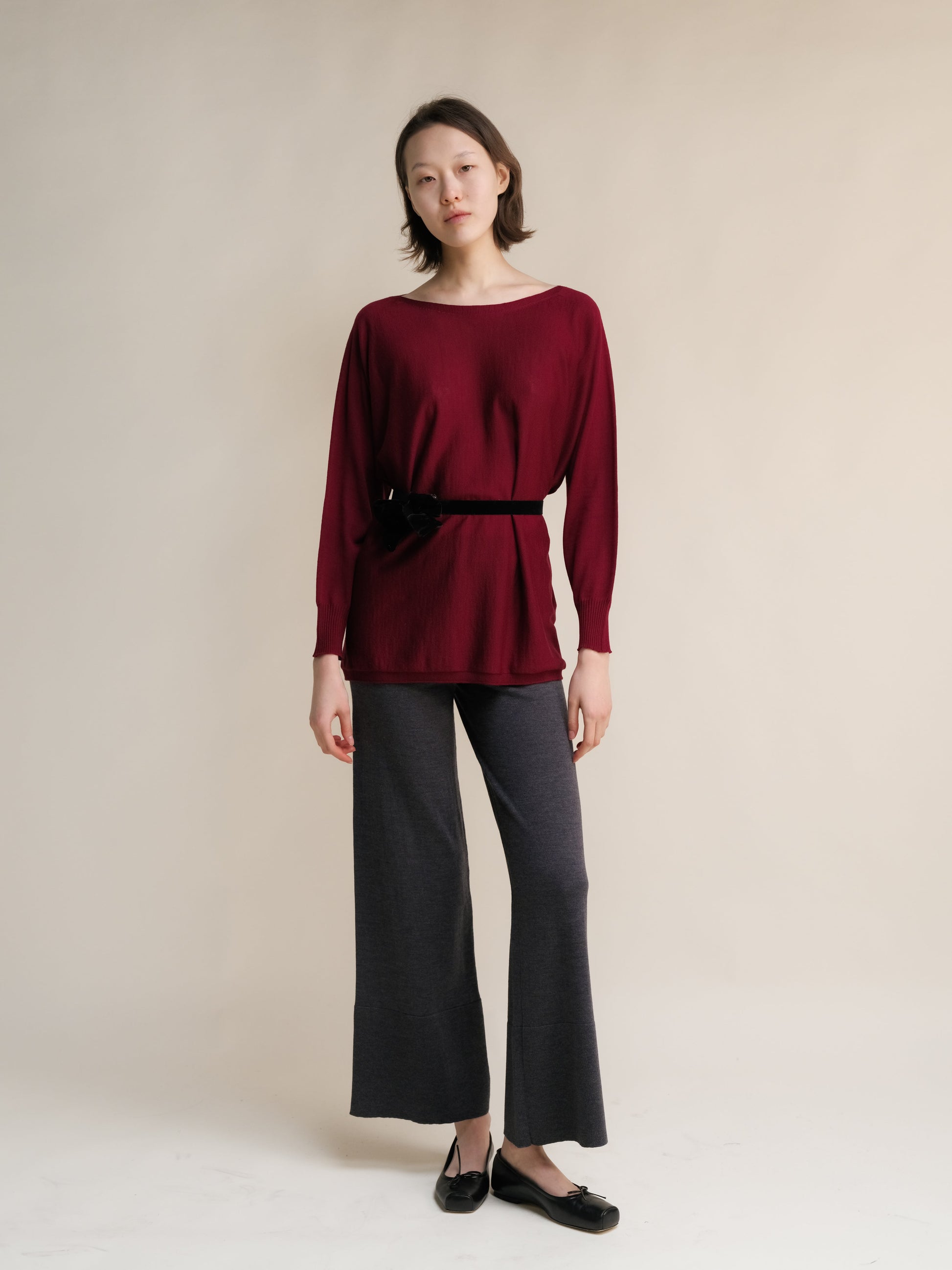 Burgundy Extra Fine Merino Wool Boat Neck Oversized Sweater with black belt, Italian Cashwool® knitwear styled with wide-leg pants.