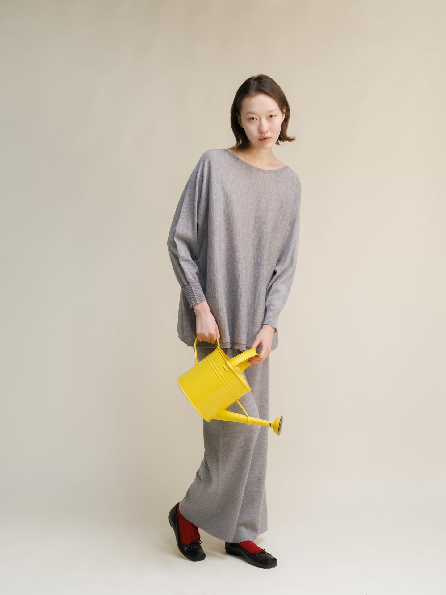 Grey Extra Fine Merino Wool Boat Neck Oversized Sweater with matching pants, Italian knitwear styled playfully with yellow watering can.