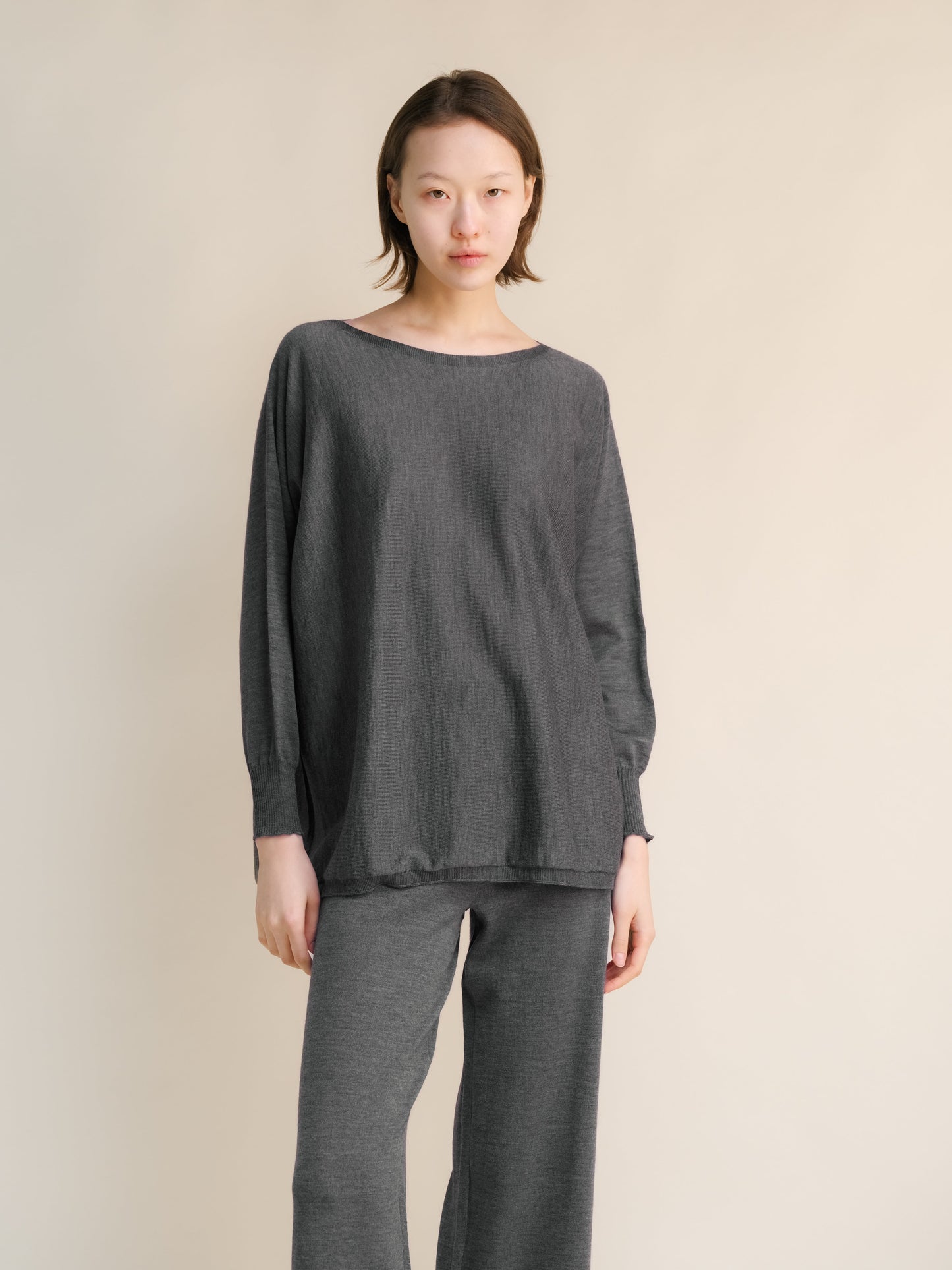 Charcoal grey Extra Fine Merino Wool Boat Neck Oversized Sweater, seamless Italian knitwear with soft drape and ribbed sleeves.