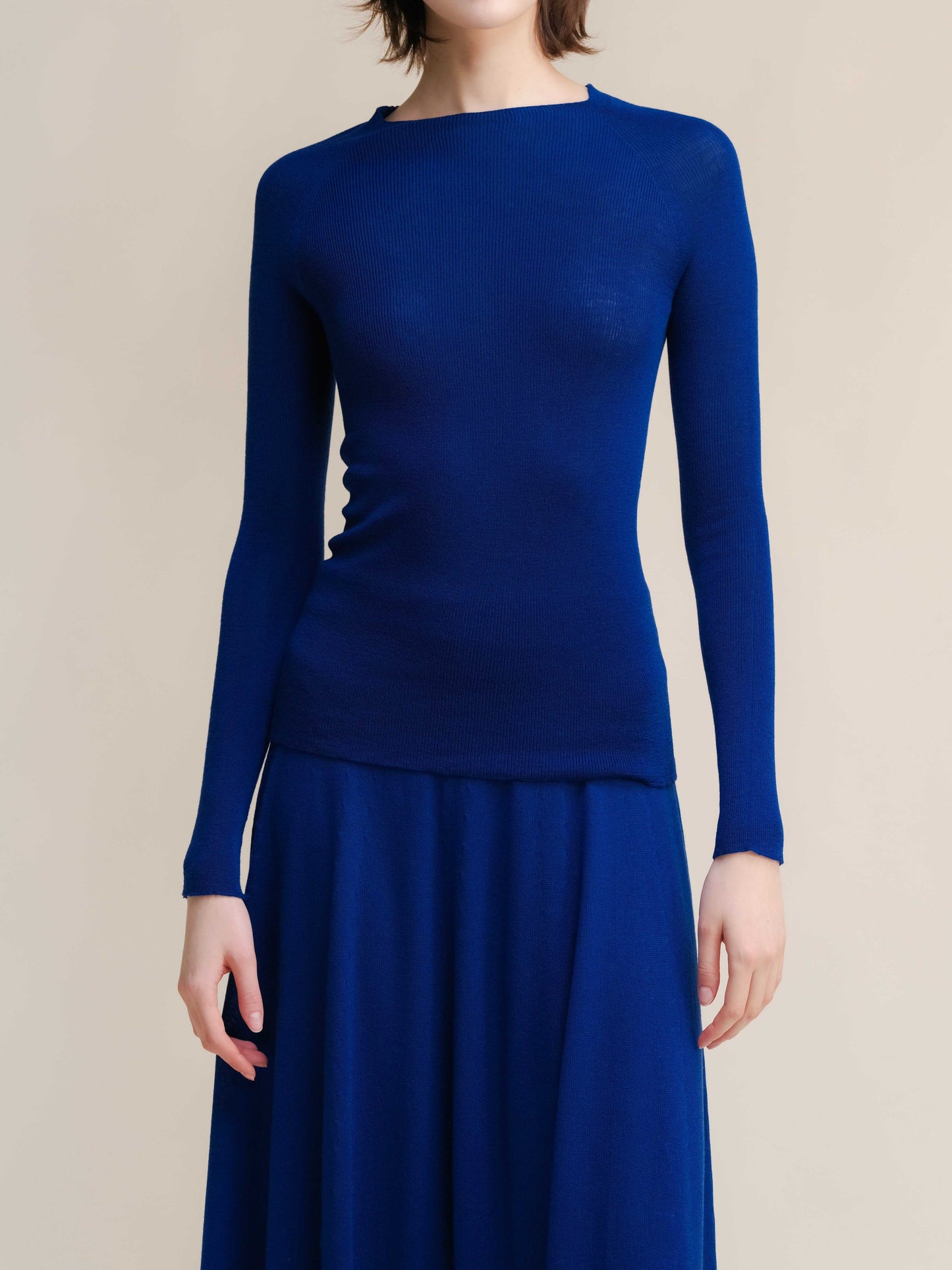 Royal blue slim fit ribbed crewneck in extra fine merino wool, styled with matching skirt. Seamless, warm knitwear for modern minimal looks.
