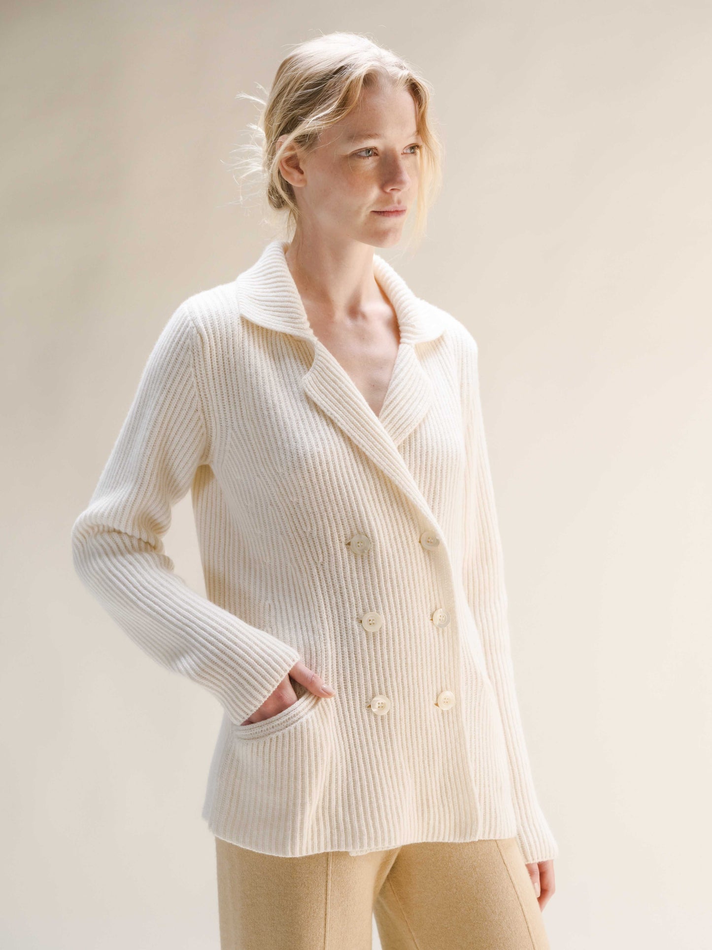 Ivory cashmere wool blend double breasted jacket with ribbed texture and elegant tailoring, ideal for refined outerwear styling.