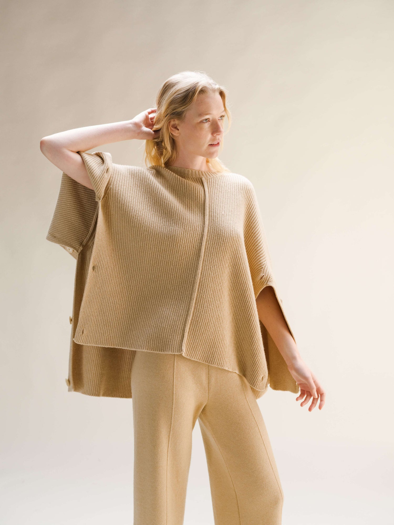 Cashmere cape sweater in camel with oversized fit and side button closures, Italian knitwear by HenryPawHaven, styled with matching pants.