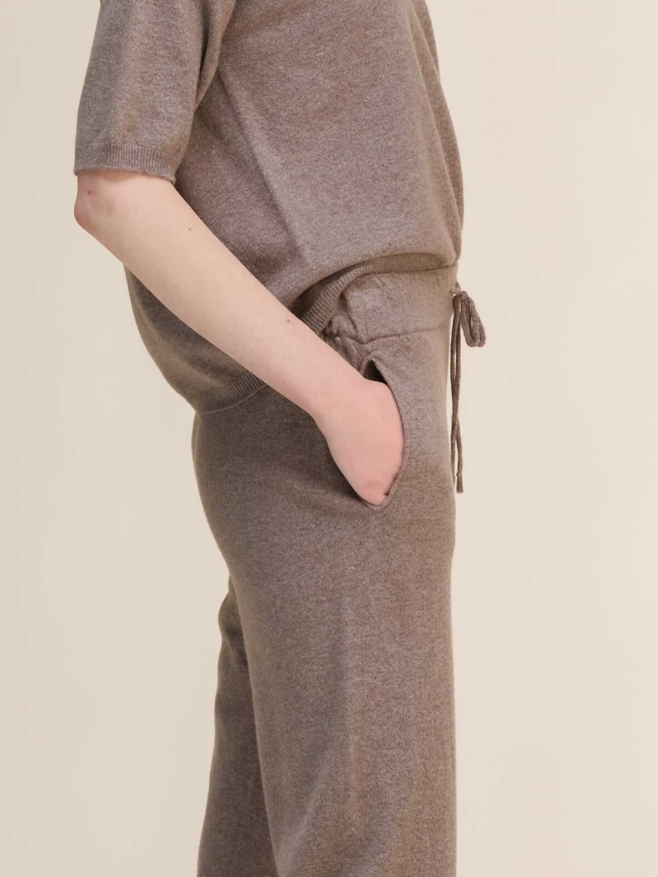 Close-up of taupe Cashmere Yoga Pants 3D-Knit highlighting drawstring waist and side pocket detail for functional comfort.