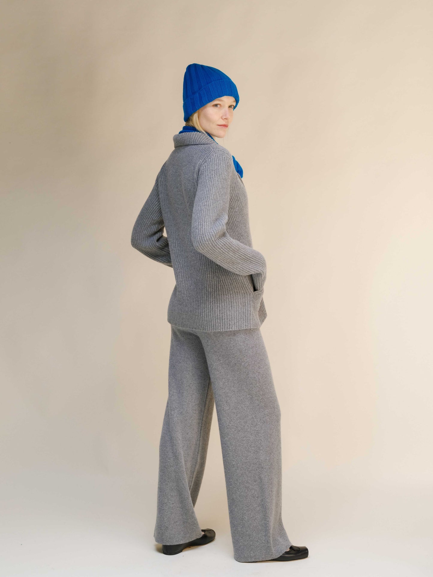 Back view of gray Italian knitwear jacket in cashmere wool blend, paired with wide-leg pants for a cozy and stylish outfit.