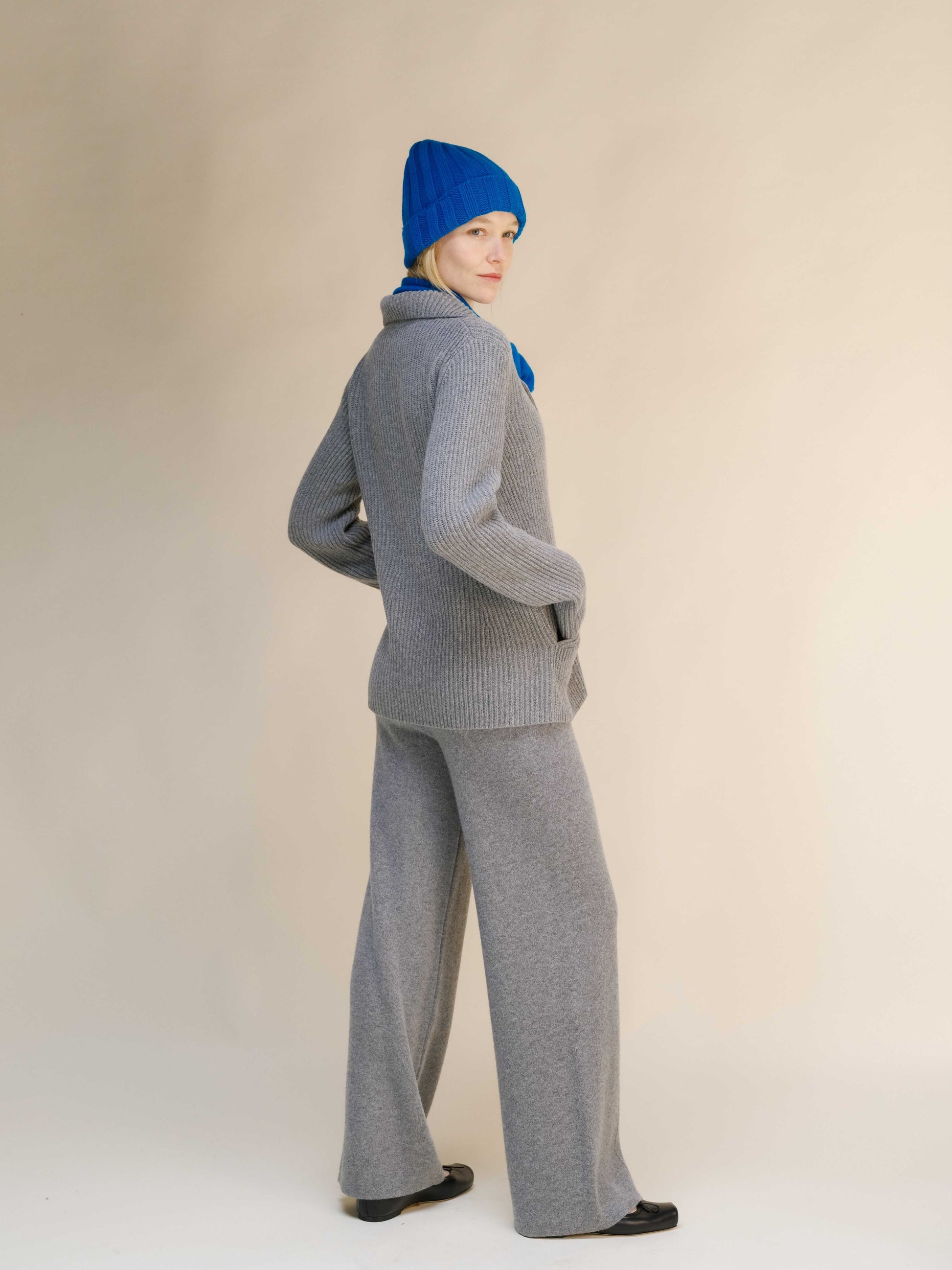 Back view of gray Italian knitwear jacket in cashmere wool blend, paired with wide-leg pants for a cozy and stylish outfit.