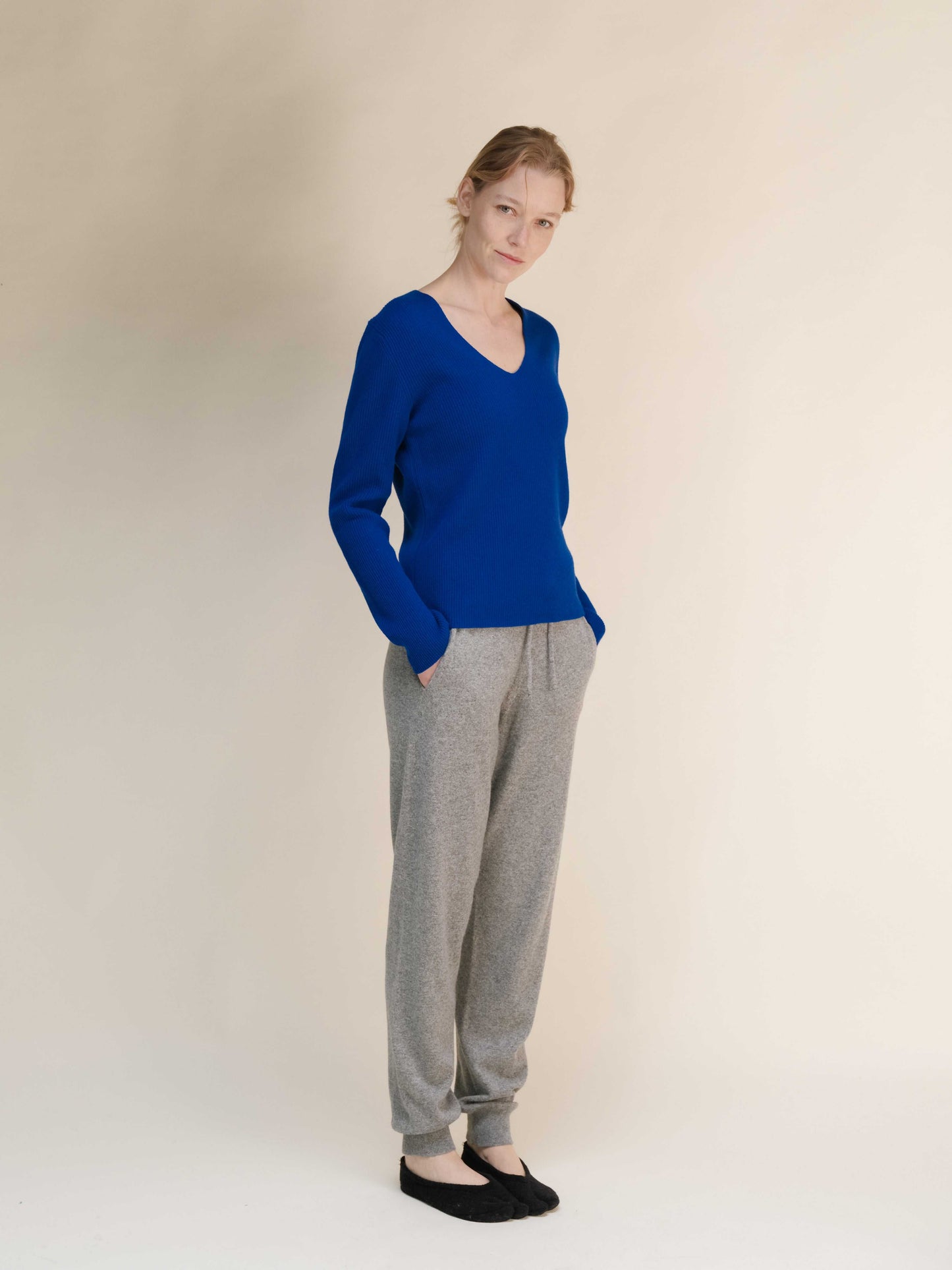 Heather grey Cashmere Yoga Pants 3D-Knit styled with royal blue sweater, featuring a relaxed silhouette and soft knit fabric.