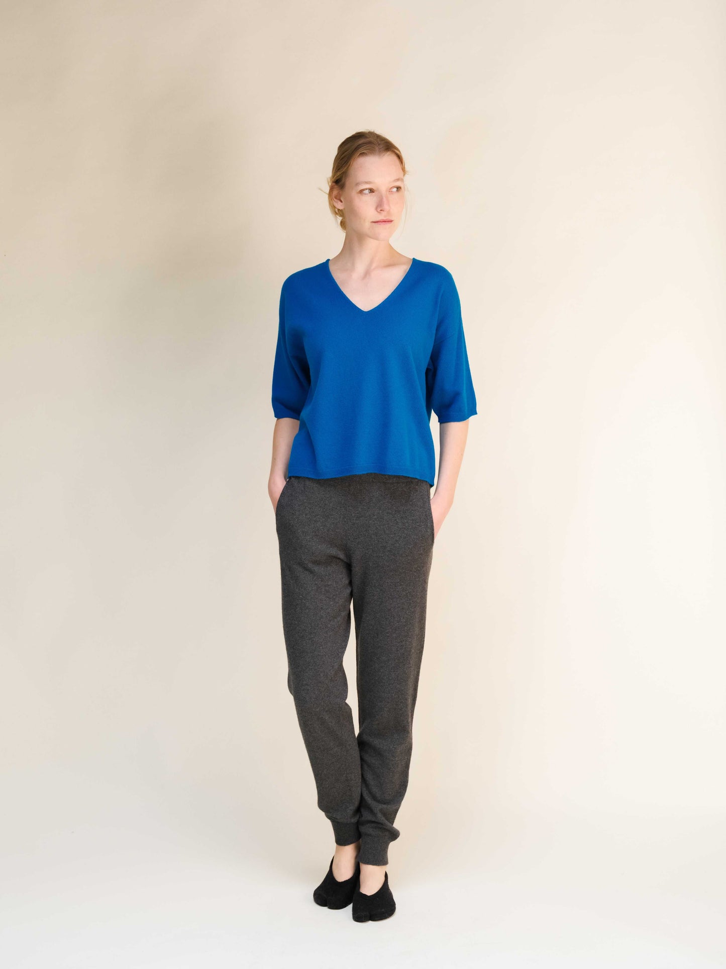 Dark grey Cashmere Yoga Pants 3D-Knit paired with cobalt blue V-neck top, offering a modern take on Italian knitwear comfort.