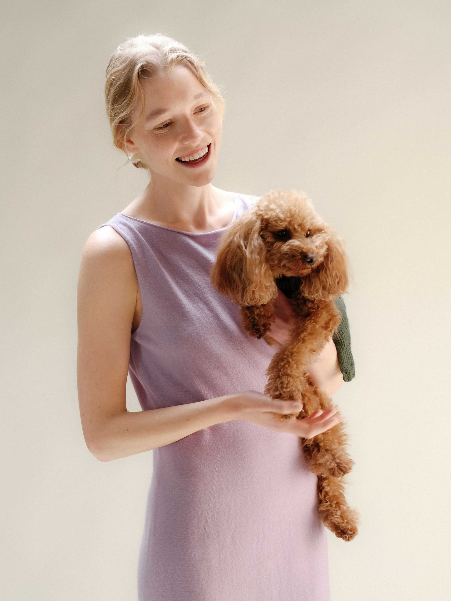 Lilac Cashmere Boat Neck Sleeveless Dress in Italian knitwear, soft 3D-knit texture, worn casually while holding a dog.