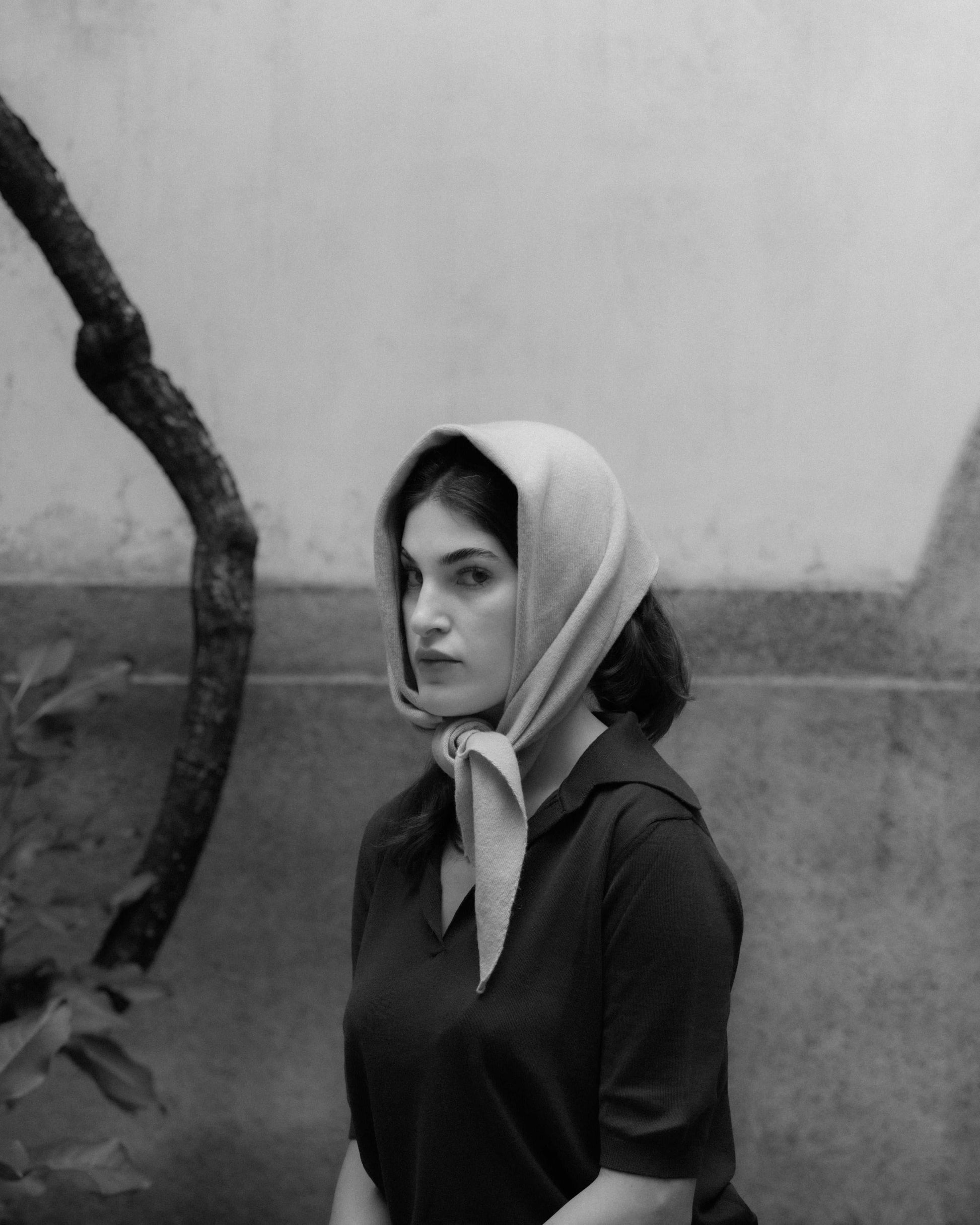 Neutral-toned Cashmere Mix Triangle Scarf styled as a head wrap. Premium Italian knitwear offering versatile fashion options.