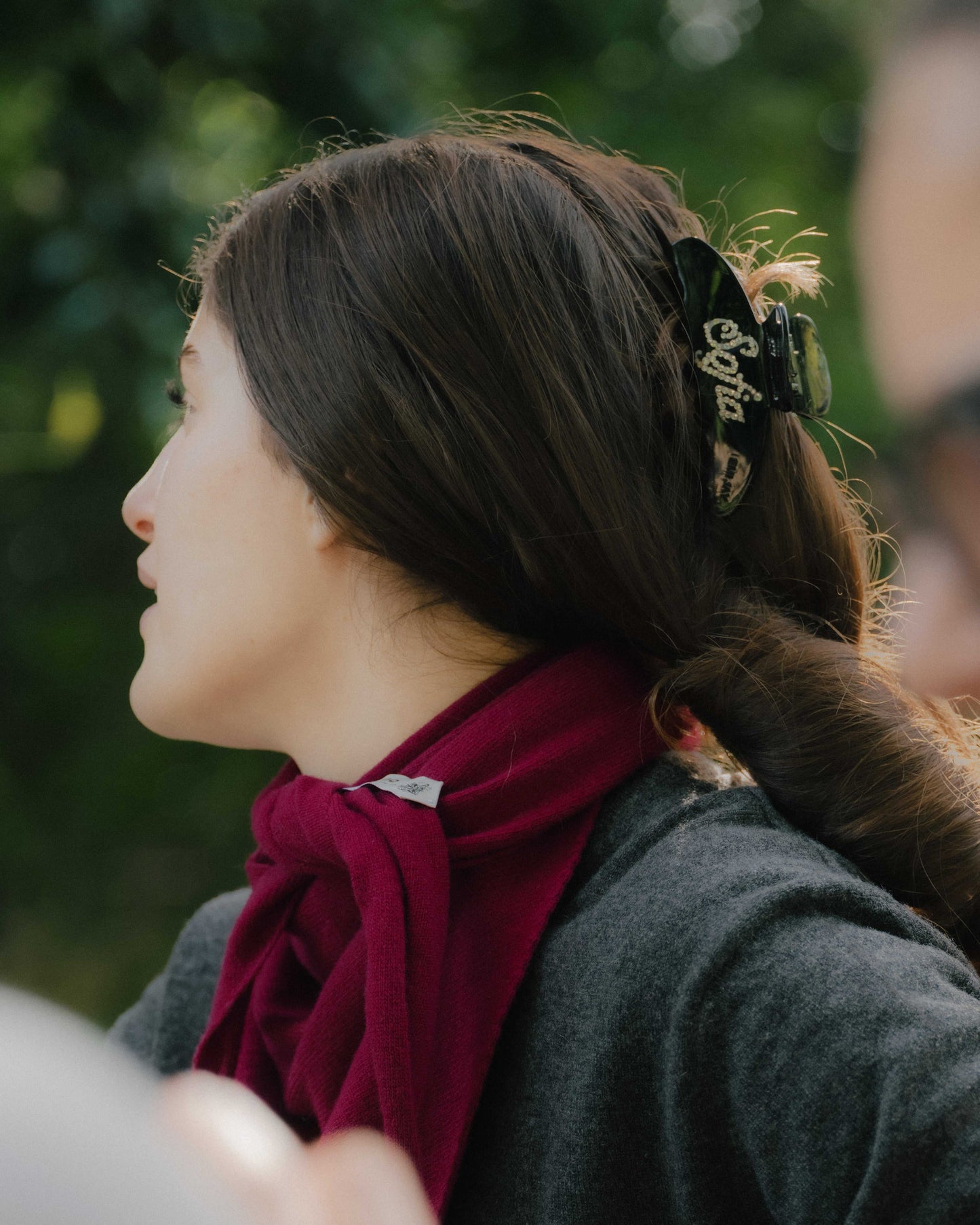 Close-up of Cashmere Mix Triangle Scarf in red tied at the neck. Soft, lightweight Italian knitwear for all-season accessorizing.