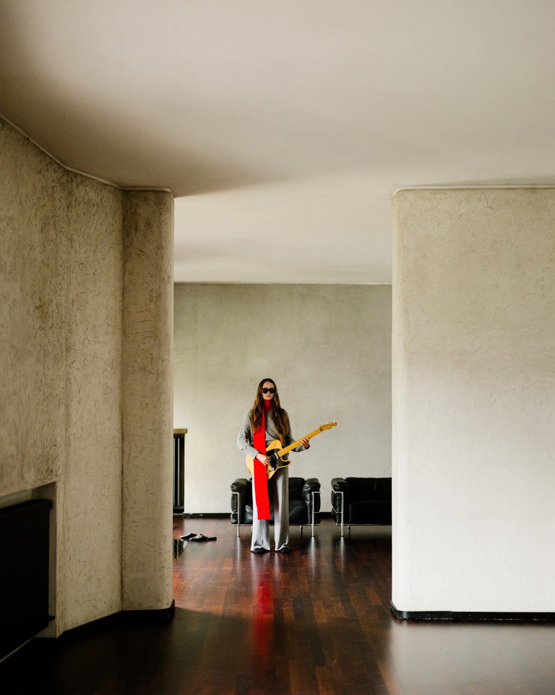 Full view of gray 3D Cashmere Mix Wide Legged Light Pants by Lèmme, styled with red scarf and guitar, showcasing Italian knitwear versatility.