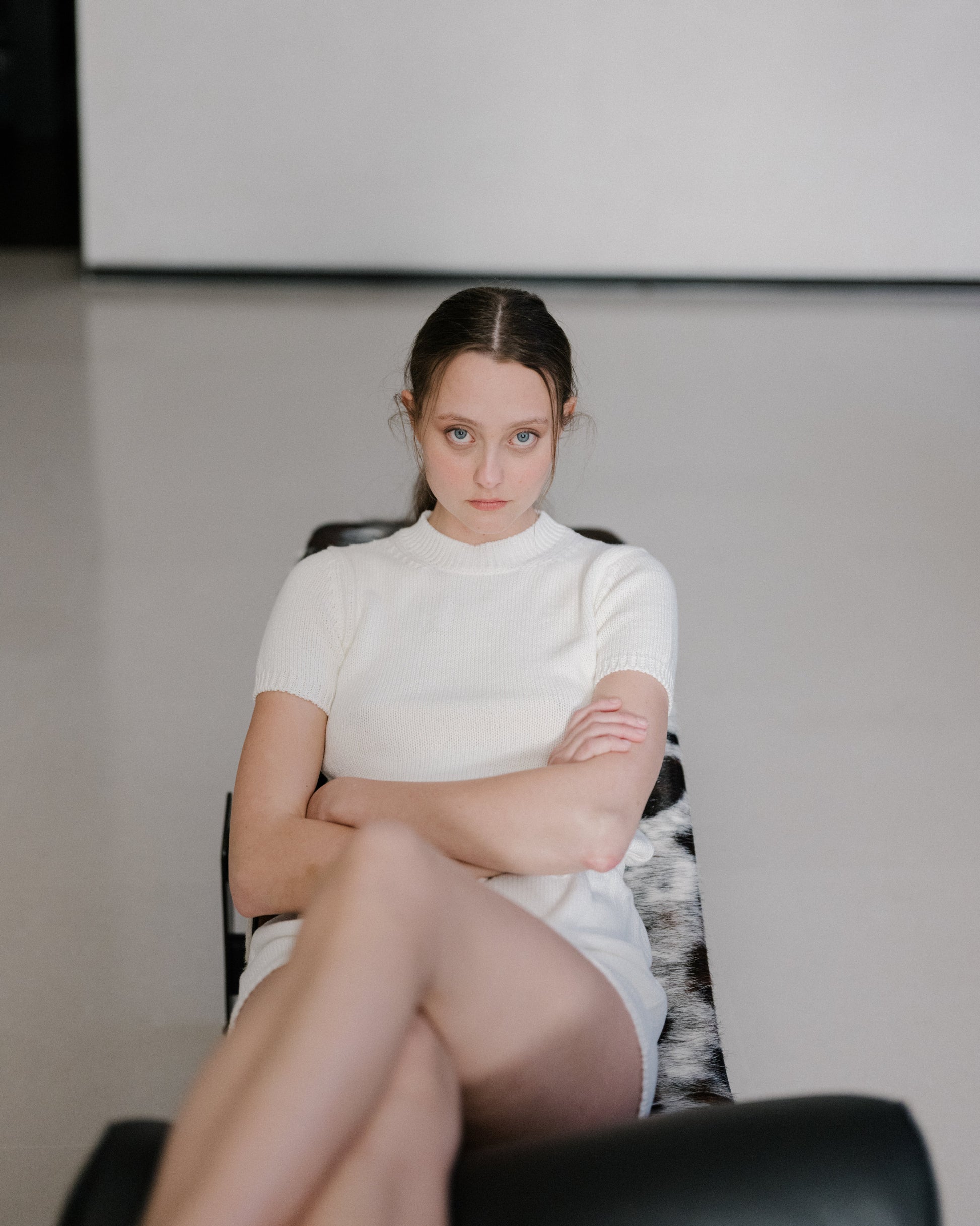 Model lounging in Fine Cotton Chunky T-Shirt in ivory. Soft and sustainable Italian knitwear with a modern chunky texture.