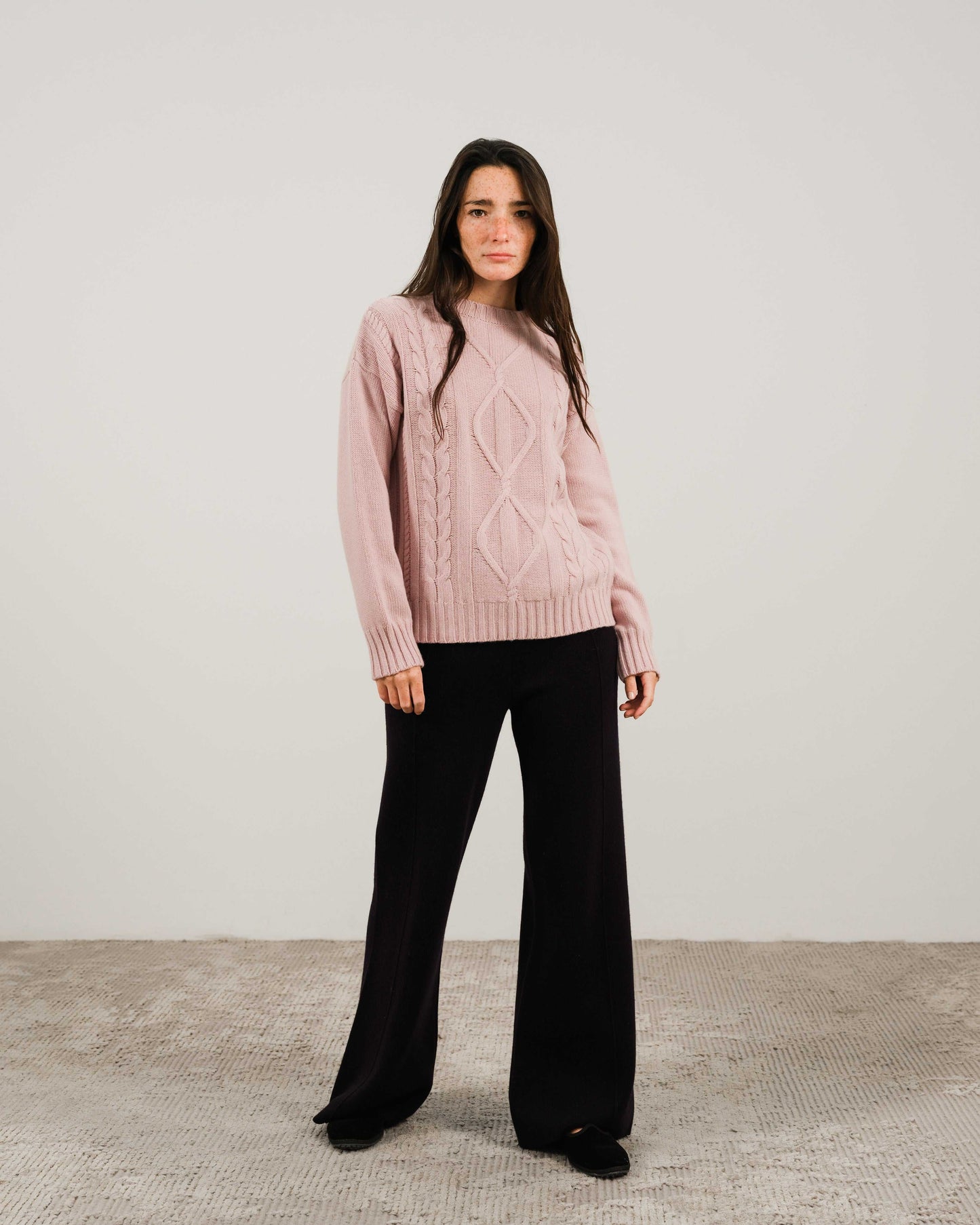 Light pink Cashmere Mix Cable Knit Sweater styled with black pants. Elegant and sustainable knitwear from HenryPawHaven for everyday comfort.