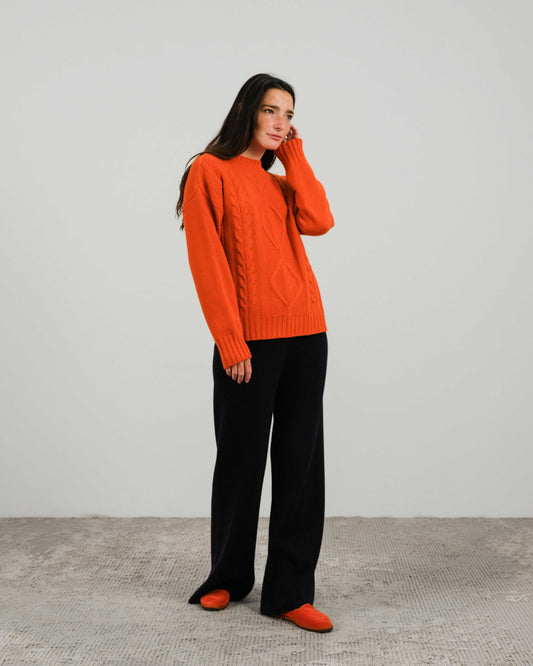 Cashmere Mix Cable Knit Sweater in vibrant orange styled with black wide-leg pants. Sustainable apparel from HenryPawHaven for elegant comfort.