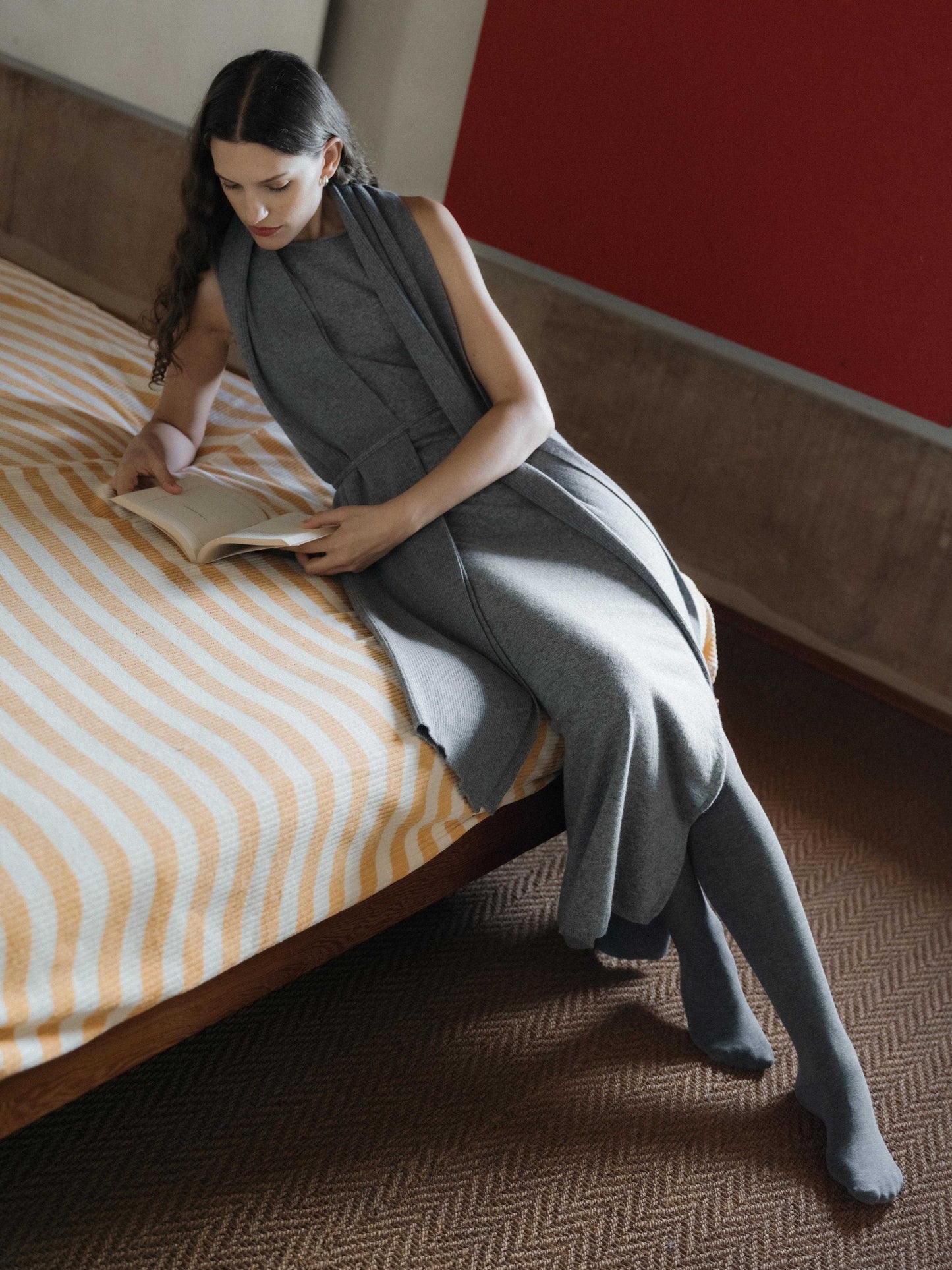 Woman lounging in grey Cashmere Boat Neck Sleeveless Dress with scarf, Italian knitwear with seamless 3D-knit texture.