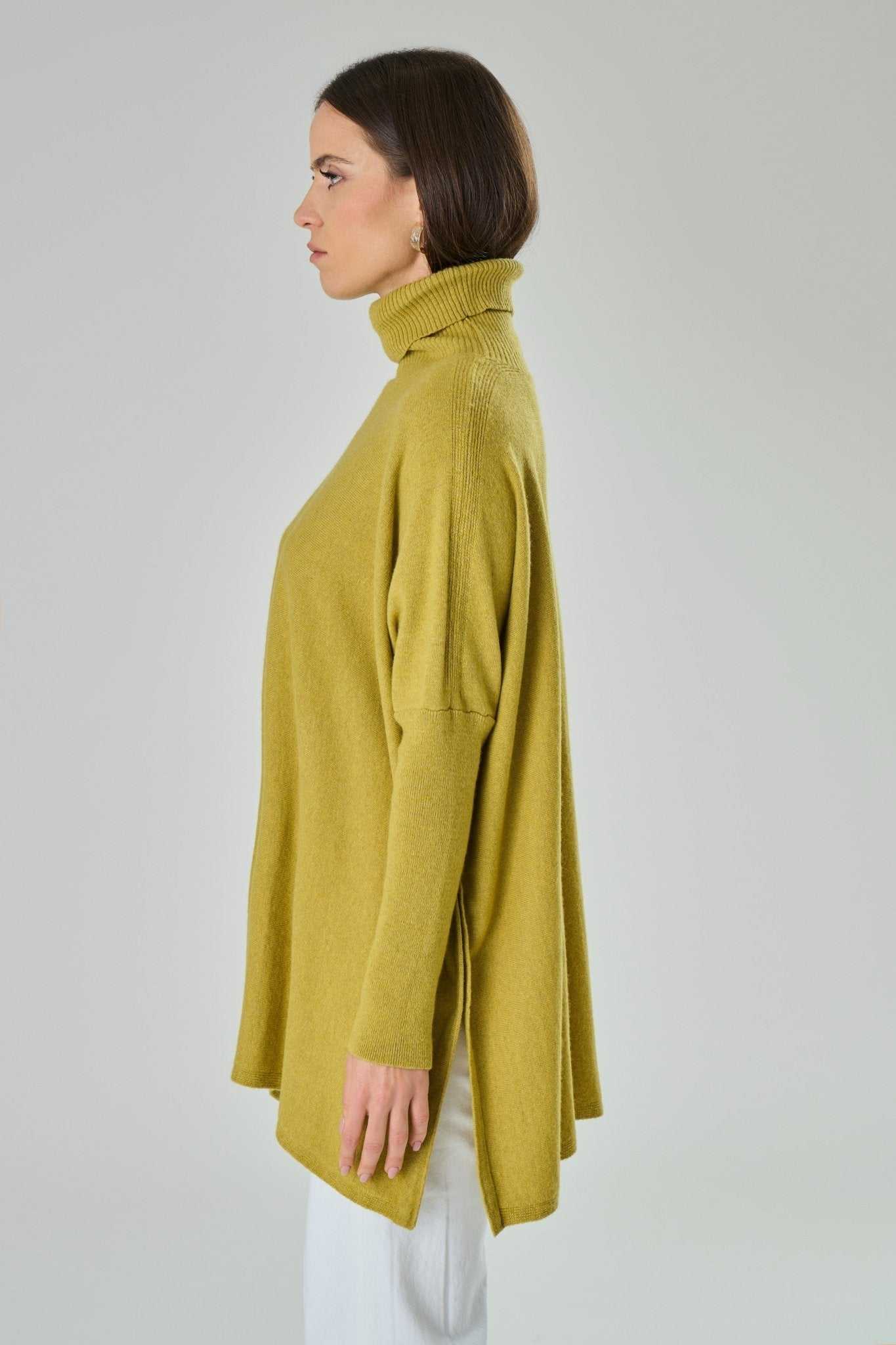 Side profile of Amalia Cashmere Blend Turtleneck Sweater in Blue by Tenné, emphasizing ribbed turtleneck and flowy oversized cut.