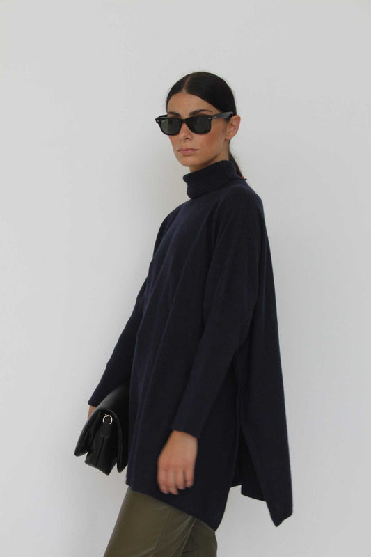 Amalia Cashmere Blend Turtleneck Sweater in Anthracite by Tenné, featuring oversized fit and ribbed collar, styled with leather pants and sunglasses.