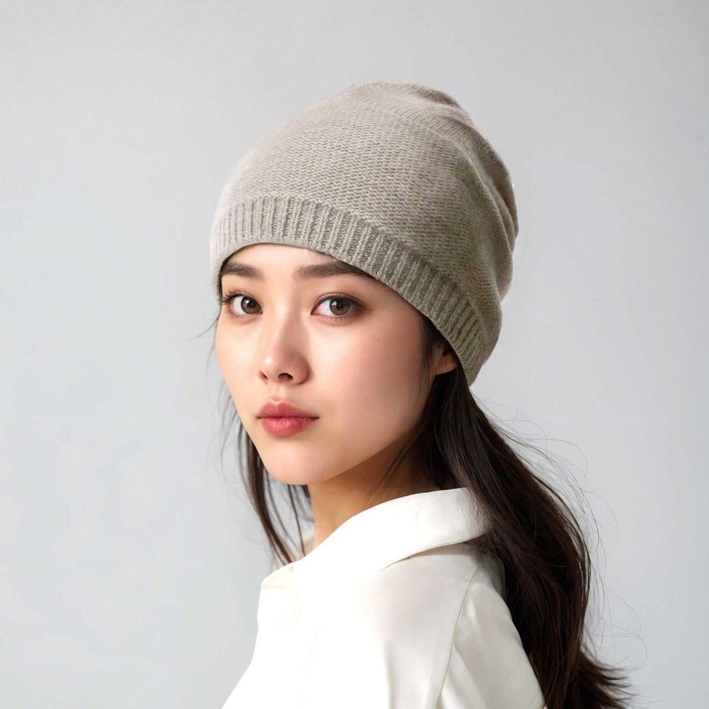 Portolano Women's Cashmere Slouchy Hat in beige worn by model. Slouchy silhouette and ribbed edge offer a chic, cozy winter accessory.