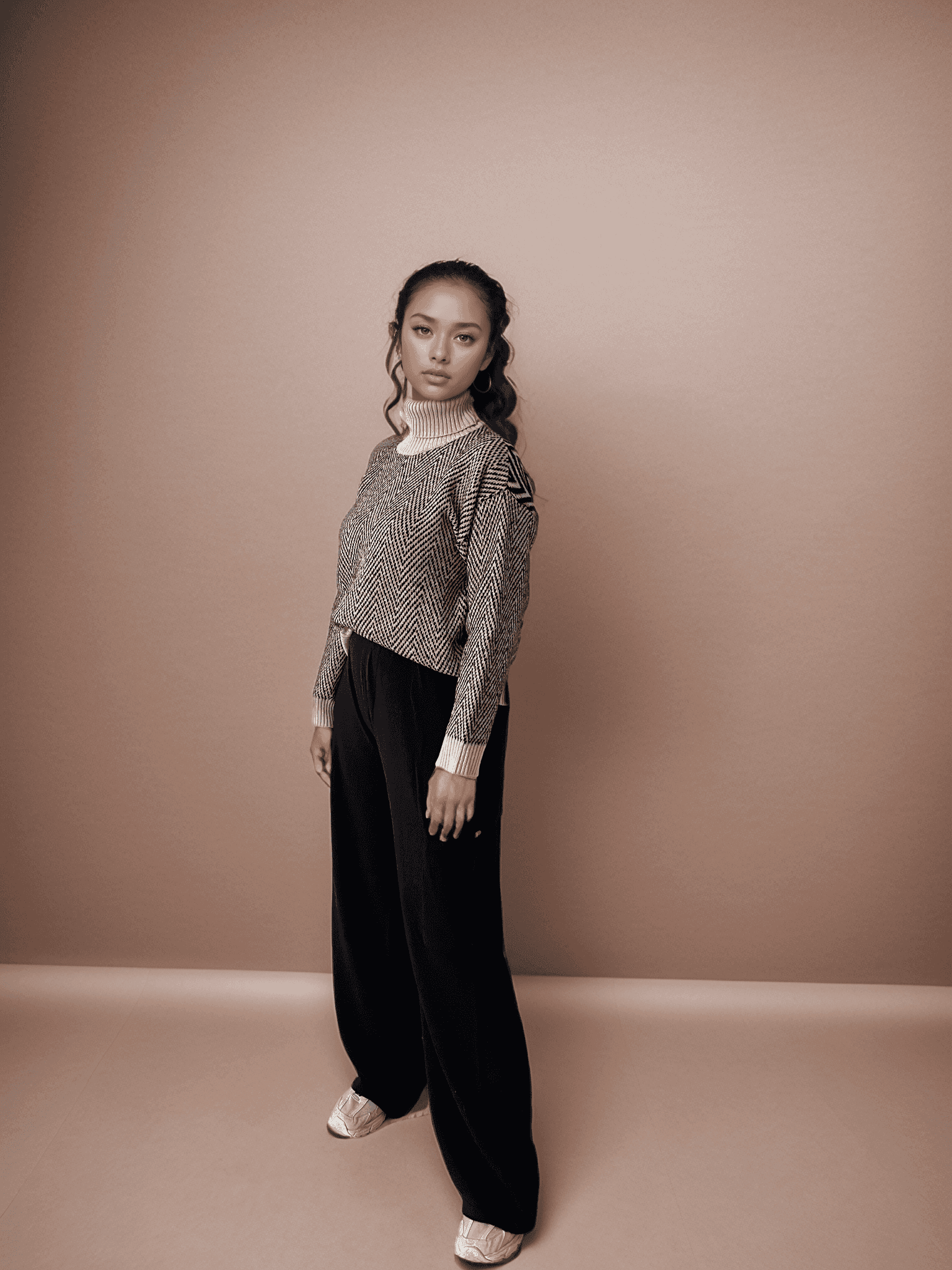 Penelope Chevron Wool Turtleneck in black and white two-tone design, styled with wide-leg black pants. Ideal for autumn/winter fashion.