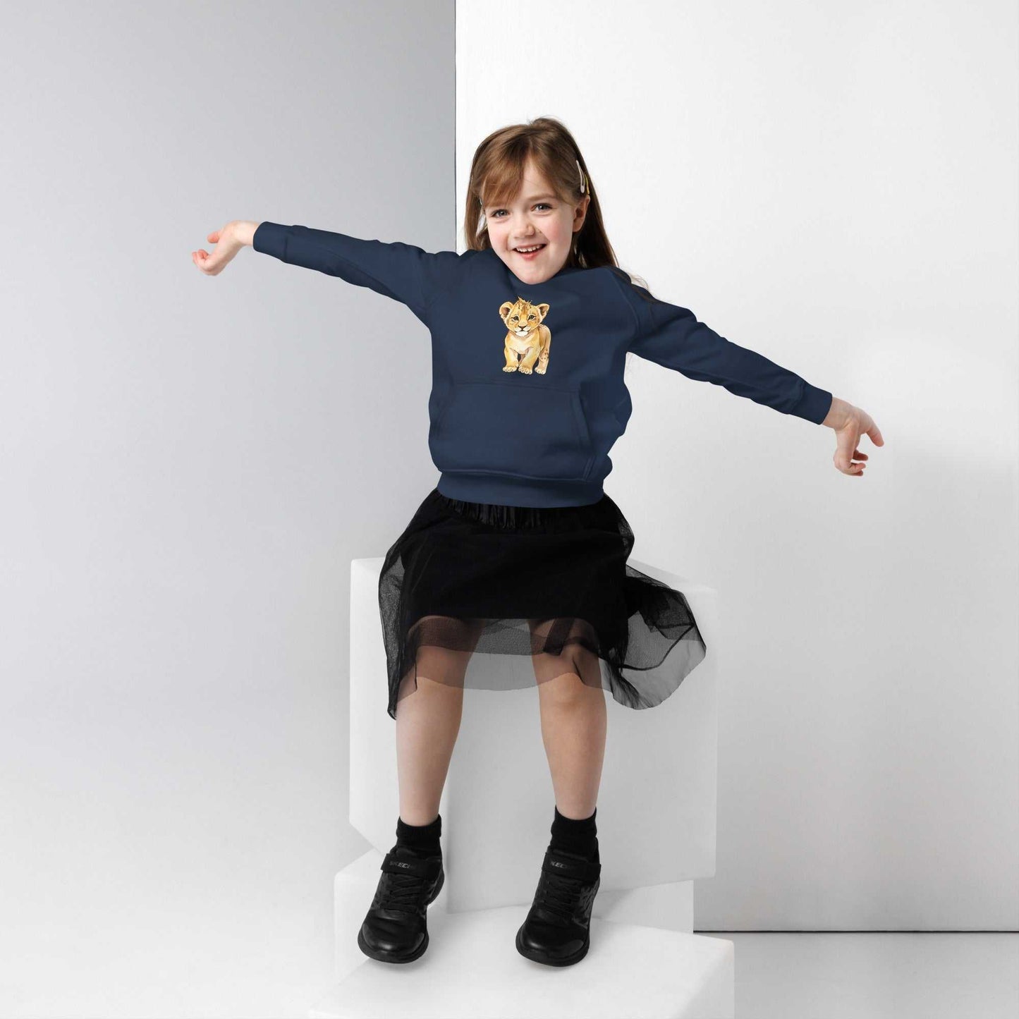 Girl in navy blue kids eco hoodie with baby lion design. Soft organic cotton hoodie ideal for active kids' wardrobes.