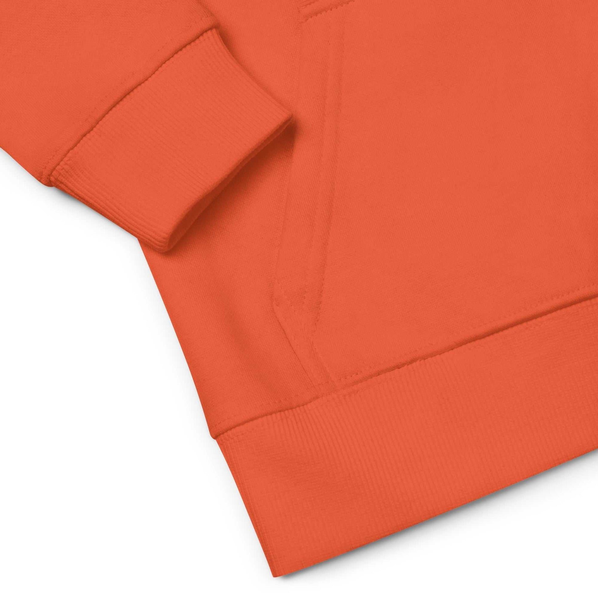 Detailed view of orange kids eco hoodie pocket and cuff. Comfortable and eco-conscious hoodie with ribbed details.
