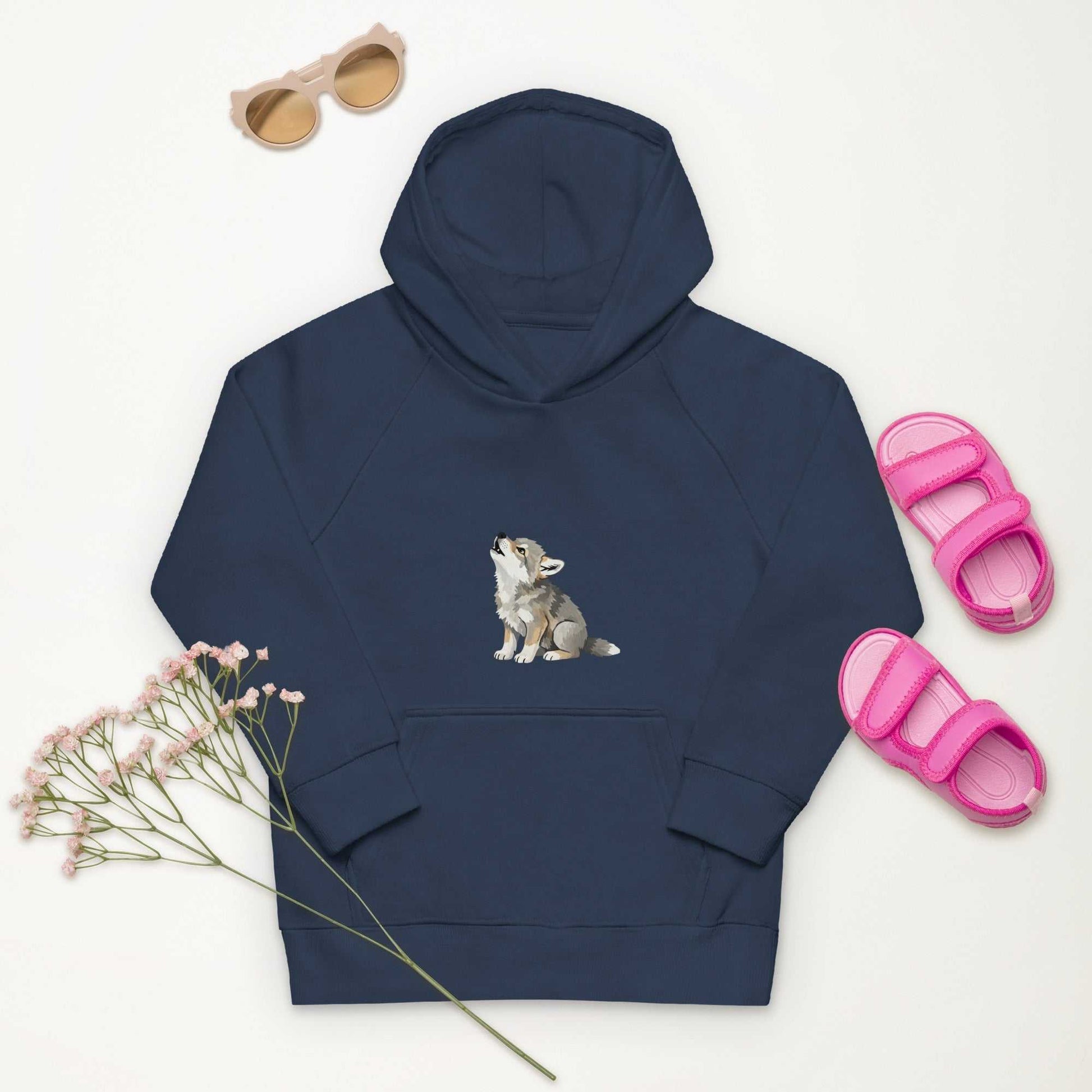 Navy kids eco hoodie with baby wolf design, styled with pink sandals and sunglasses. Soft and sustainable kidswear.