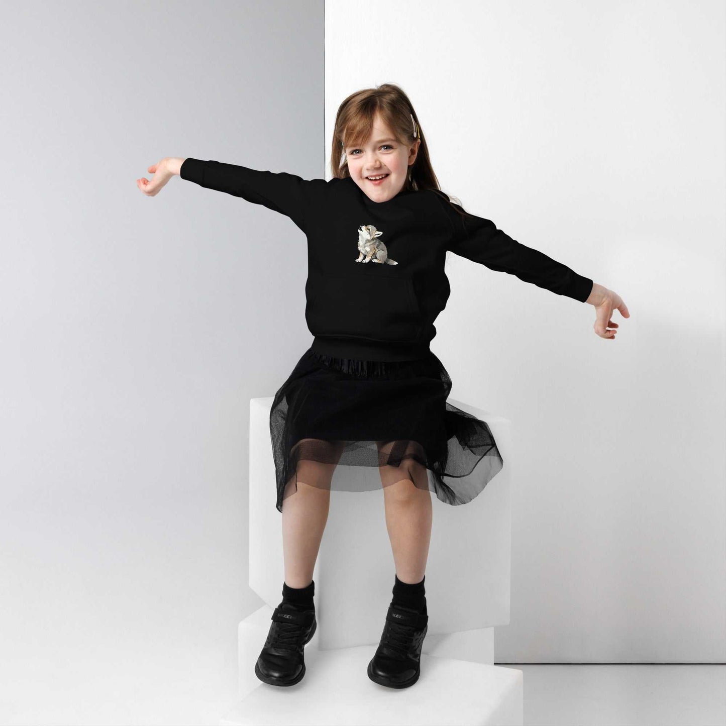 Black kids eco hoodie with baby wolf print, worn by a girl. Soft organic cotton hoodie perfect for stylish and sustainable children's clothing.