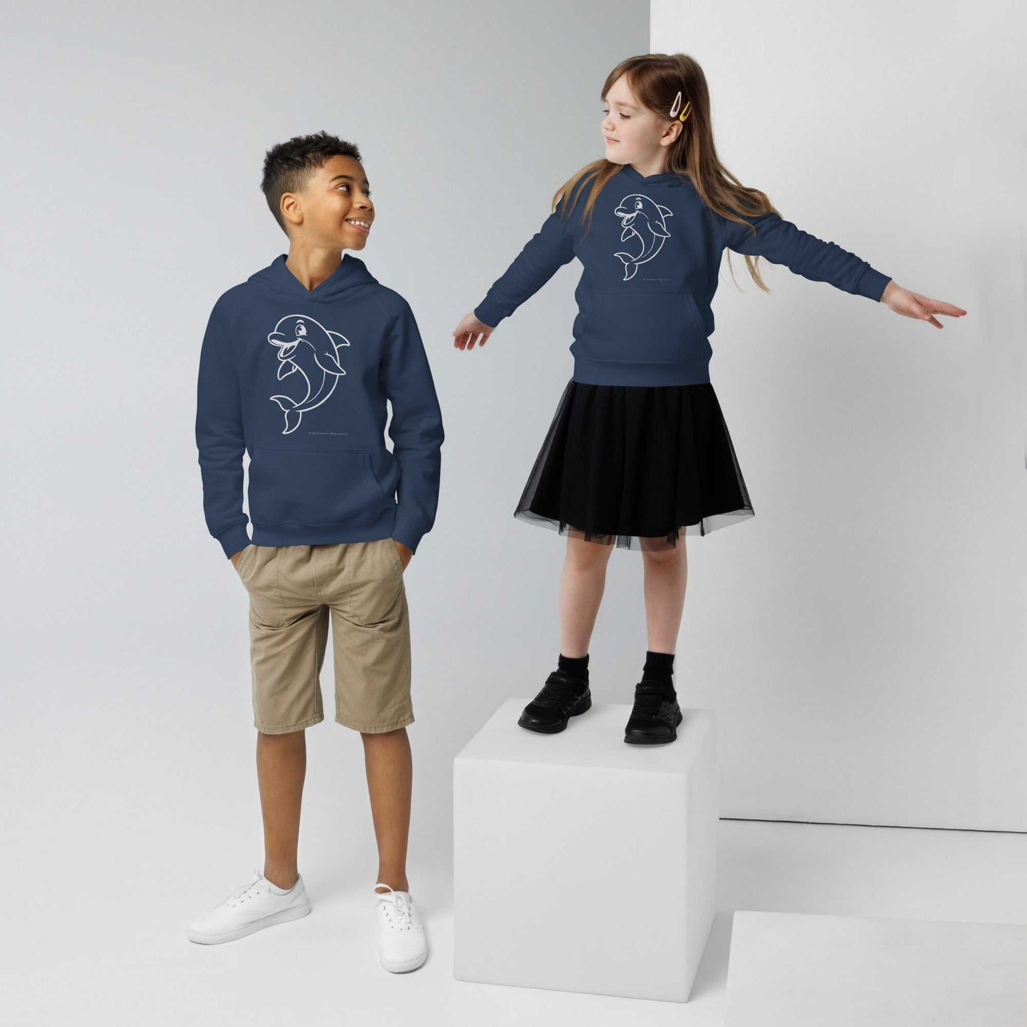 Navy Kids Eco Hoodie Dolphin modeled by two kids, featuring dolphin graphic. Sustainable hoodie for playful and stylish children.