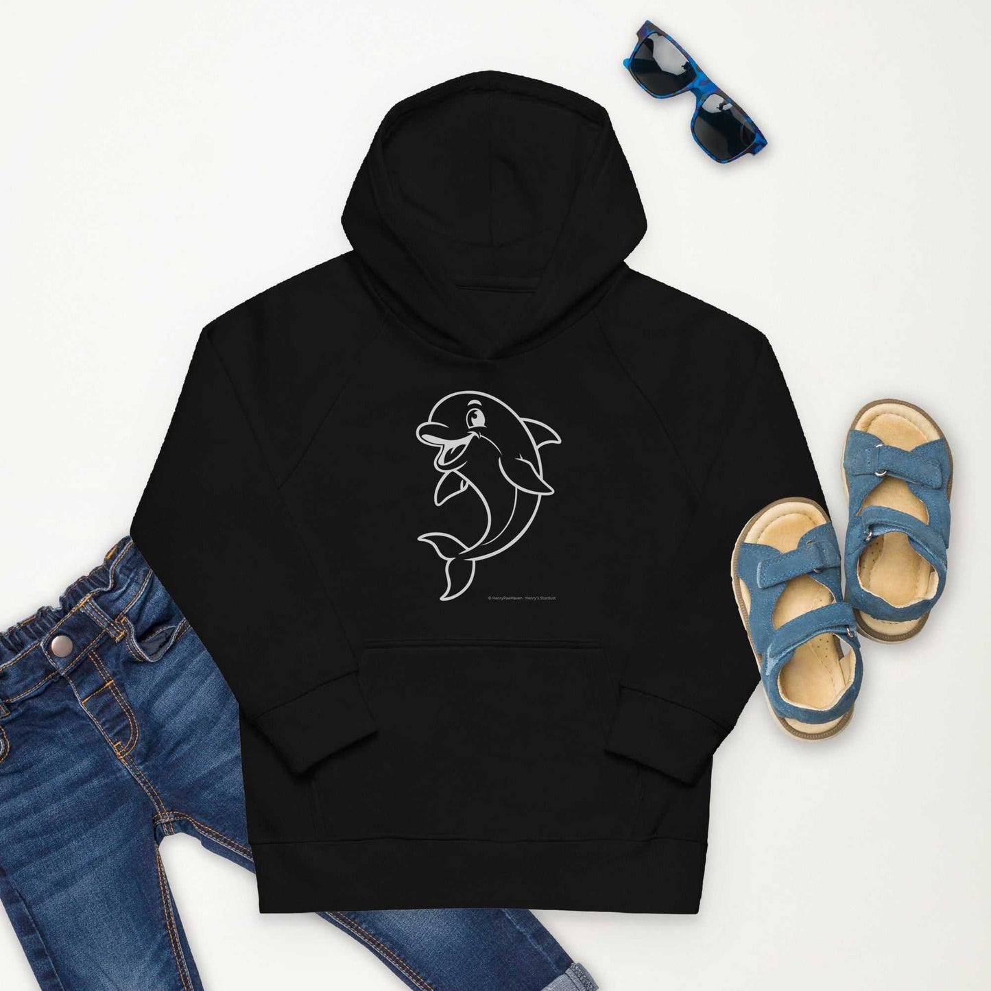 Flat lay of black Kids Eco Hoodie Dolphin with dolphin print, paired with jeans, sandals, and sunglasses. Organic cotton and recycled polyester.
